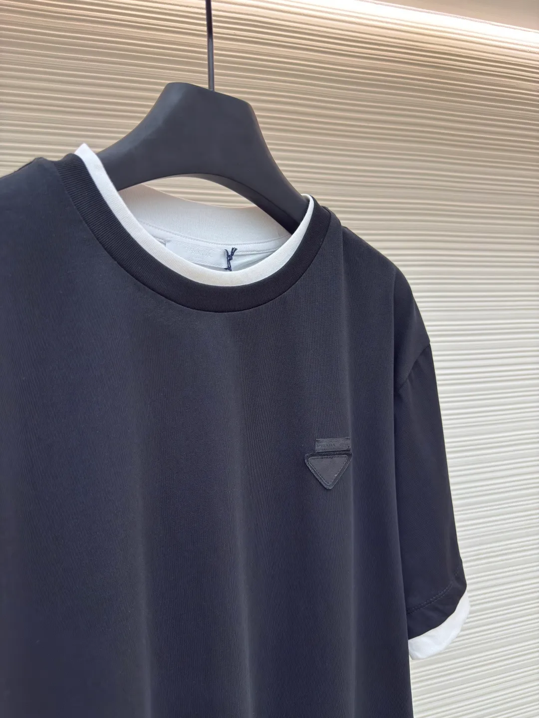 Prada triangular cloth label round neck short sleeves ●Authentic product: Purchased and developed by 4570 ●Item number: 1680228-A10 ●Fabric: Special woven dense cotton fabric ●Technology: Made on positioning cutting machine ●Version: Fitted version ●Weight: about 260 grams ●Size: XS-S-M-L ●Description: Made of 24S special woven compact cotton fabric, 185g; with 40S double yarn thread, 220g. The strength of compact yarn is higher than that of traditional single yarn. The single fibers in compact yarn are closely arranged, which helps to improve the strength of the yarn. The ends of the fibers are all twisted into the yarn, so the yarn is very tight and the yarn has a smooth appearance with less hairiness. Compact spinning yarn has higher strength and less hairiness, making it less prone to fraying. The characteristics of the classic brand's triangular woven label are innovative breakthroughs from three dimensions: material collision, structural craftsmanship and symbolic narrative. The three-dimensional thickness is formed by hot-pressing composite. Because it can be woven with woven yarn raw materials, laser cut and restored, it has different characteristics in terms of temperature resistance. The classic round neck basic version design adopts a double-layer neckline and asymmetrical hem with a fake two-piece structure, and the side seams form a three-dimensional box silhouette. Create a visual dislocation effect through the collision and stacking of color blocks. The triangle logo on the front chest is heat-embossed to create a matte and slightly reflective contrast with the main fabric. The overall wiring is straight and delicate, the fabric is comfortable and soft, and the color is consistent without color difference. It can be matched with the same style to create a fashionable look and control various occasions. Customized accessories, complete with three standards, same style for men and women!