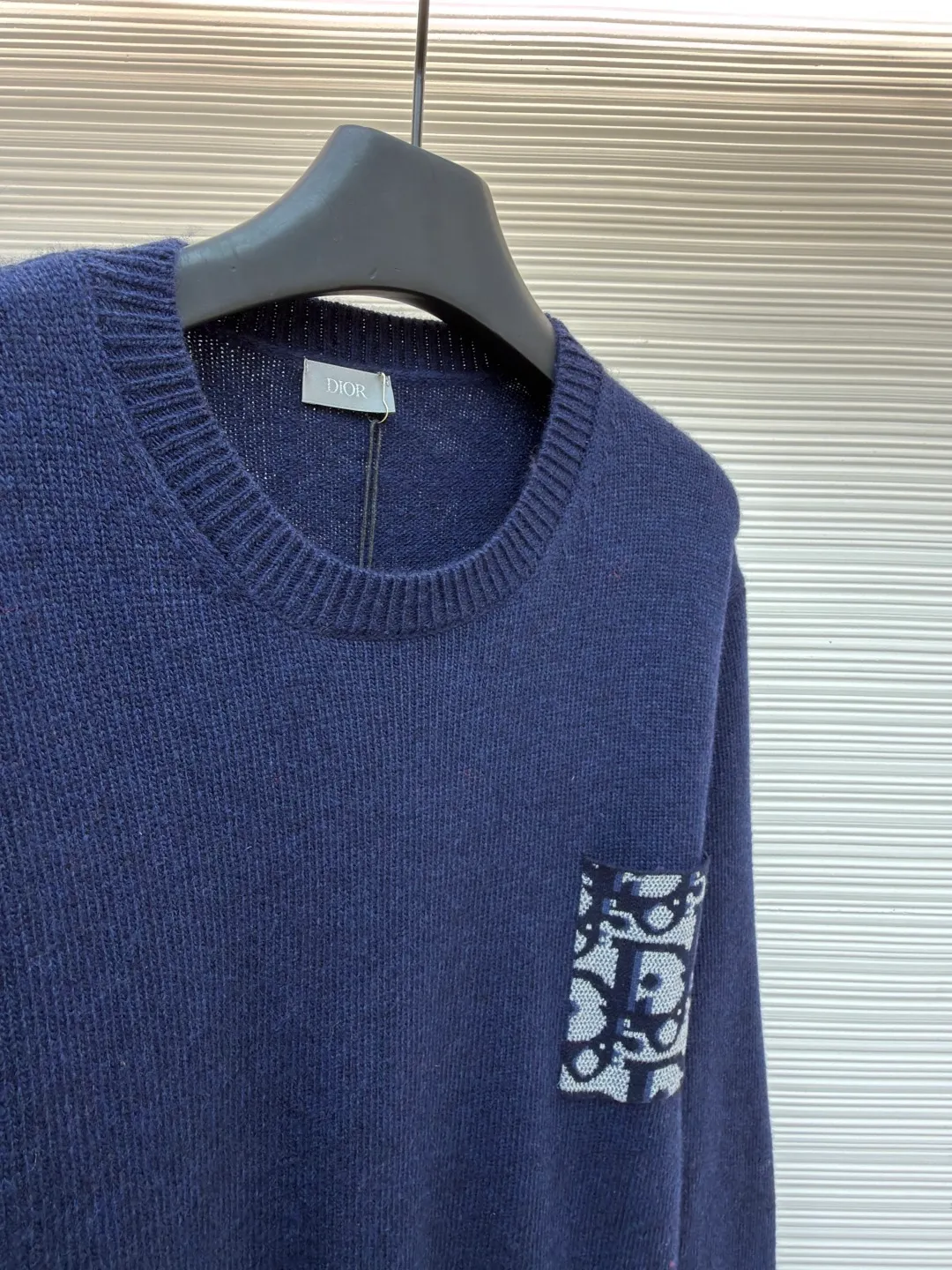 Dior patchwork letter jacquard pocket knitted sweater ●Original version: purchased and developed in 19049 ●Item number: 1682530-B10 ●Fabric: wool fabric ●Technology: jacquard knitting ●Color: navy blue ●Version: fitted version ●Weight: about 560 grams ●Size: S-M-L-XL ●Description: This DIOR The SS26 summer series red sweater is woven with high-quality combed cotton threads and uses plain knitting technology to create the body. The fabric is fine, soft, elastic, breathable and skin-friendly, and is not prone to pilling or snagging. The brand's classic presbyopia pattern pocket on the left side of the body is made using patch printing technology. The printing ink layer is thick and even, and the pattern is clear and three-dimensional. It forms a sharp visual contrast with the red knitted base and highlights the brand recognition. The neckline is a classic round neck design, with double-needle reinforced hemming technology and a custom-made threaded collar, making it durable and not prone to loosening. The cuffs and hem are ribbed in the same color, with moderate elasticity to fit the body shape. The overall cut is a fitted silhouette. The stitching is straight and fine. The customized accessories and three labels are complete. The details and craftsmanship show the level of luxury. It is suitable for daily casual and light business wear scenarios. The overall wiring is straight and delicate, the fabric is comfortable and soft, and the color is consistent without color difference. It can be matched with the same style to create a fashionable look and control various occasions. Customized accessories, complete with three standards, same style for men and women!