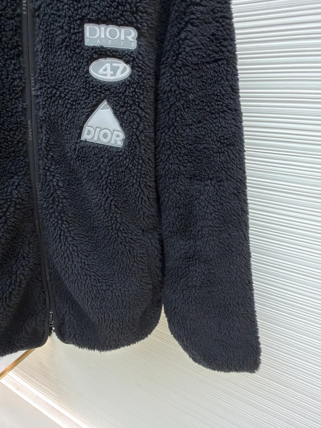 Dior x descentn ski jacket ●Original version: Purchased and developed by 23775 ●Item number: 1681706-B70 ●Fabric: polyester fiber fabric ●Technology: Positioning cutting machine production ●Color: black ●Version: fitted version ●Weight: about 745 grams ●Size: S-M-L-XL ●Description: This Dior plush zipper jacket adopts a loose fit design, which is comfortable to wear and has excellent warmth retention. The fabric is made of high-quality imitation sherpa material, which has a soft and delicate feel, good warmth retention and breathability. Ready-to-wear garments are made using precision cutting techniques to ensure the overall shape is three-dimensional and crisp. The brand logo and decorative pattern on the chest are embossed, and the pattern is clear and three-dimensional, highlighting the high-end quality of the brand. The details of the zippers and pockets are exquisite, the overall wiring is neat, and the stitching is fine and firm. The high collar design not only increases warmth, but also adds fashion to the overall look. Whether it is daily wear or outdoor activities, it can be easily controlled, perfectly interpreting the luxury and functionality of the Dior brand. The overall wiring is straight and delicate, the fabric is comfortable and soft, and the color is consistent without color difference. It can be matched with the same style to create a fashionable look and control various occasions. Customized accessories, complete with three standards, same style for men and women!