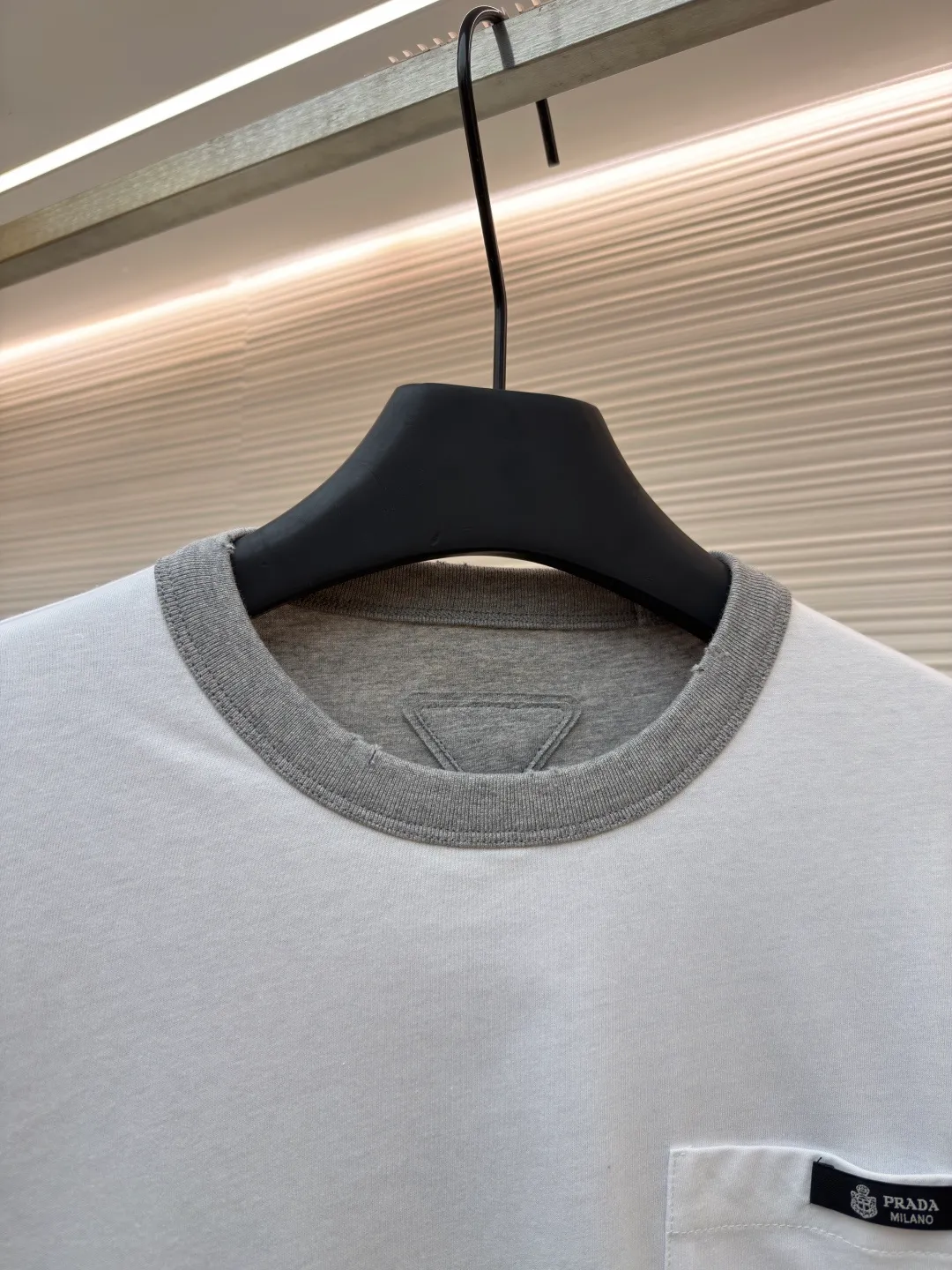 Prada double-sided design logo short sleeves ●Original version: Purchased and developed at 9150 ●Item number: 1682528-A15 ●Material: Velvet-feel plain cotton fabric ●Technology: Precision splicing and seaming production ●Color: Gray ●Version: Fitted version ●Weight: about 280 grams ●Size: S-M-L-XL ●Description: Customized velvet-feel plain cotton, soft and delicate, comfortable and close to the skin, twin aesthetics of gray and white interweaving Wearing the minimalist philosophy of two souls, the cloud white on the front uses Prada label details to define high-end restraint. The contrasting rib collar locks all eyes. The high-grade gray on the back uses the back triangle to highlight the essence of the brand. It is a quiet but unignorable presence. Combined with the frayed design, it is sublimated, filled with artistic atmosphere, double-sided elegance, and leads the trend. Precise splicing and seaming technology uses advanced sewing technology and equipment to ensure that the splicing of each short sleeve is smooth and tight, with smooth lines, and there will be no gaps inside and outside. The neckline is sewn using a computerized double-needle sewing process, using an advanced control system to sew two parallel stitches at the same time. Ensure that the size and shape of the neckline remain consistent, and use positioning and manual fraying. Local friction and wear on the fabric through manual operation will cause a natural damage effect on the surface of the fabric. The overall wiring is straight and delicate, the fabric is comfortable and soft, and the color is consistent without color difference. It can be matched with the same style to create a fashionable look and control various occasions. Customized accessories, complete with three standards, same style for men and women!