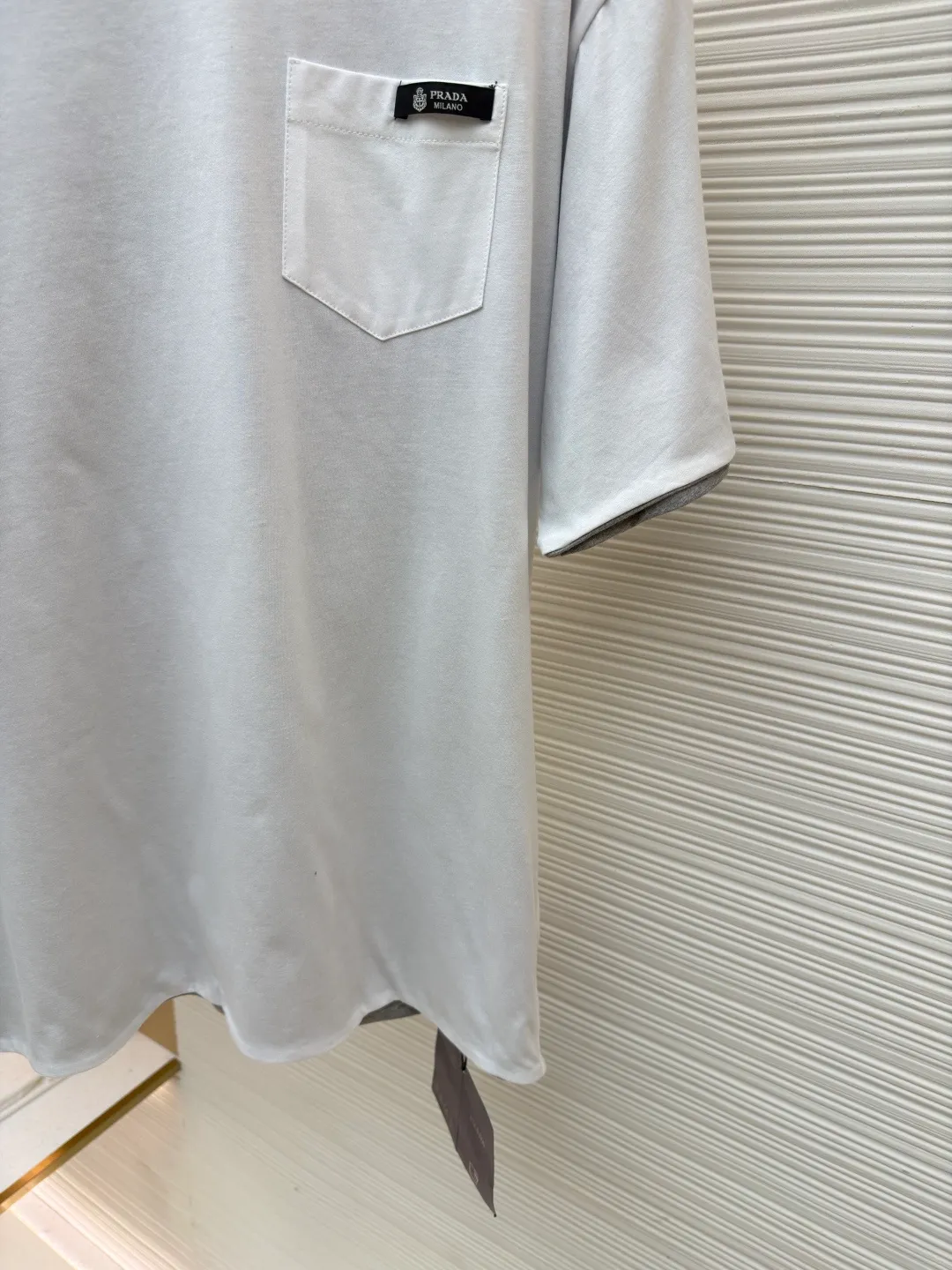 Prada double-sided design logo short sleeves ●Original version: Purchased and developed at 9150 ●Item number: 1682528-A15 ●Material: Velvet-feel plain cotton fabric ●Technology: Precision splicing and seaming production ●Color: Gray ●Version: Fitted version ●Weight: about 280 grams ●Size: S-M-L-XL ●Description: Customized velvet-feel plain cotton, soft and delicate, comfortable and close to the skin, twin aesthetics of gray and white interweaving Wearing the minimalist philosophy of two souls, the cloud white on the front uses Prada label details to define high-end restraint. The contrasting rib collar locks all eyes. The high-grade gray on the back uses the back triangle to highlight the essence of the brand. It is a quiet but unignorable presence. Combined with the frayed design, it is sublimated, filled with artistic atmosphere, double-sided elegance, and leads the trend. Precise splicing and seaming technology uses advanced sewing technology and equipment to ensure that the splicing of each short sleeve is smooth and tight, with smooth lines, and there will be no gaps inside and outside. The neckline is sewn using a computerized double-needle sewing process, using an advanced control system to sew two parallel stitches at the same time. Ensure that the size and shape of the neckline remain consistent, and use positioning and manual fraying. Local friction and wear on the fabric through manual operation will cause a natural damage effect on the surface of the fabric. The overall wiring is straight and delicate, the fabric is comfortable and soft, and the color is consistent without color difference. It can be matched with the same style to create a fashionable look and control various occasions. Customized accessories, complete with three standards, same style for men and women!