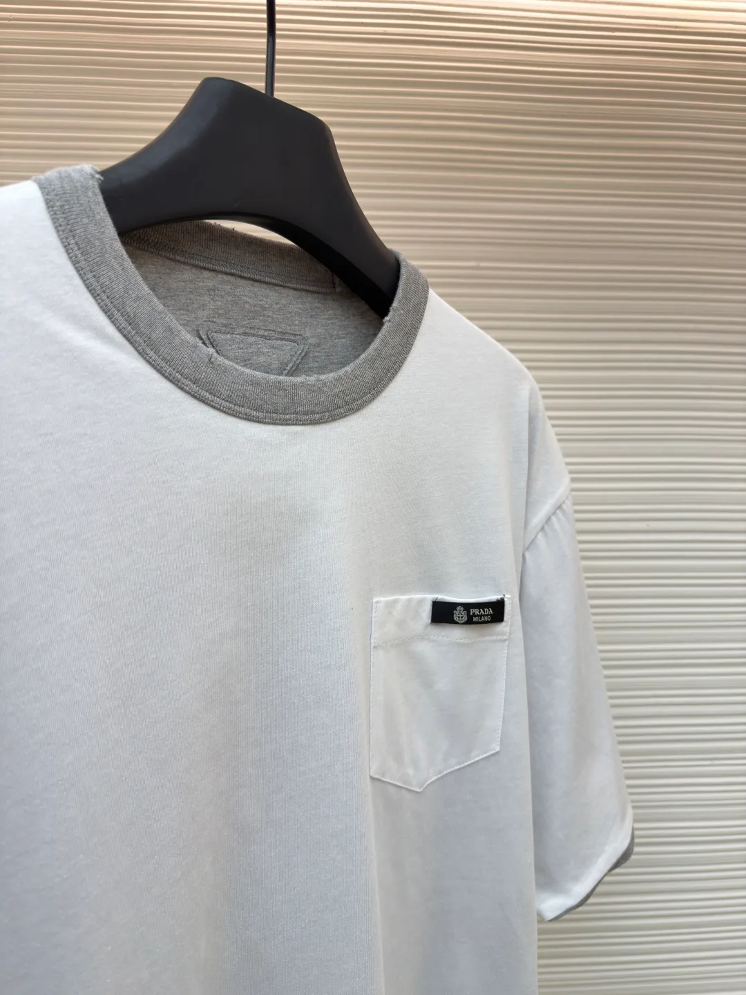 Prada double-sided design logo short sleeves ●Original version: Purchased and developed at 9150 ●Item number: 1682528-A15 ●Material: Velvet-feel plain cotton fabric ●Technology: Precision splicing and seaming production ●Color: Gray ●Version: Fitted version ●Weight: about 280 grams ●Size: S-M-L-XL ●Description: Customized velvet-feel plain cotton, soft and delicate, comfortable and close to the skin, twin aesthetics of gray and white interweaving Wearing the minimalist philosophy of two souls, the cloud white on the front uses Prada label details to define high-end restraint. The contrasting rib collar locks all eyes. The high-grade gray on the back uses the back triangle to highlight the essence of the brand. It is a quiet but unignorable presence. Combined with the frayed design, it is sublimated, filled with artistic atmosphere, double-sided elegance, and leads the trend. Precise splicing and seaming technology uses advanced sewing technology and equipment to ensure that the splicing of each short sleeve is smooth and tight, with smooth lines, and there will be no gaps inside and outside. The neckline is sewn using a computerized double-needle sewing process, using an advanced control system to sew two parallel stitches at the same time. Ensure that the size and shape of the neckline remain consistent, and use positioning and manual fraying. Local friction and wear on the fabric through manual operation will cause a natural damage effect on the surface of the fabric. The overall wiring is straight and delicate, the fabric is comfortable and soft, and the color is consistent without color difference. It can be matched with the same style to create a fashionable look and control various occasions. Customized accessories, complete with three standards, same style for men and women!