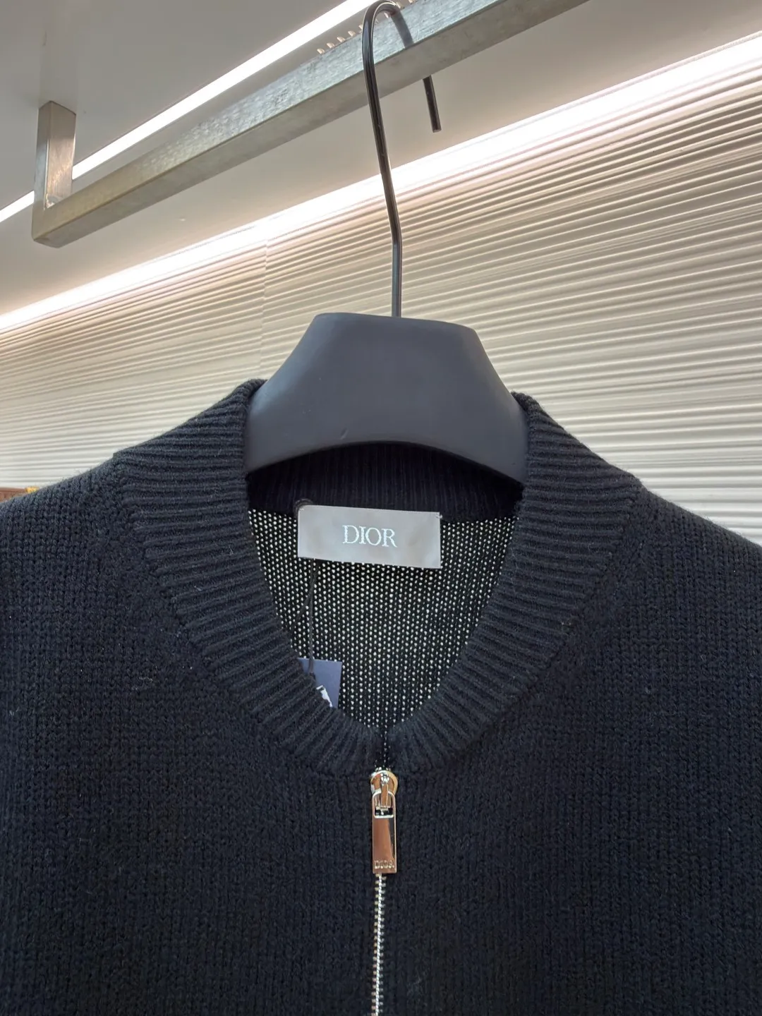 Dior letter embroidered wool knitted cardigan ●Original version: Purchased and developed by 18684 ●Item number: 1682138-C05 ●Fabric: wool blended fabric ●Technology: knitting ●Color: black ●Version: fitted version ●Weight: about 755 grams ●Size: S-M-L-XL ●Description: This Dior black knitted zipper cardigan is made of high-count worsted wool and mulberry silk blended yarn. It is woven with plain knitting technology on an Italian 16-needle computerized flat machine. The yarn is first treated with anti-pilling and pre-shrunk to make the garment soft and resistant to deformation. The Dior logo on the front chest adopts dark embroidery technology, using matte embroidery thread of the same color, completed with 0.1mm fine stitching, which is low-key and rich in texture; the three-dimensional Dior letters on the back use hand-made rope embroidery techniques, and the woven rope straps are fixed segment by section according to the outline of the version, forming a 3D relief effect. The connection between the rope strap and the body adopts invisible locking technology, without any abrupt threads. The inner side of the collar is spliced ​​with breathable mesh fabric, the metal zipper is made of custom matte nickel material, and the teeth are treated with wear-resistant treatment. The ribbed edges of the cuffs and hem have built-in elastic spandex yarn, and are hand-ironed and shaped. Every craftsmanship detail is in line with Dior's high-end ready-to-wear production standards. The overall wiring is straight and delicate, the fabric is comfortable and soft, and the color is consistent without color difference. It can be matched with the same style to create a fashionable look and control various occasions. Customized accessories, complete with three standards, same style for men and women!
