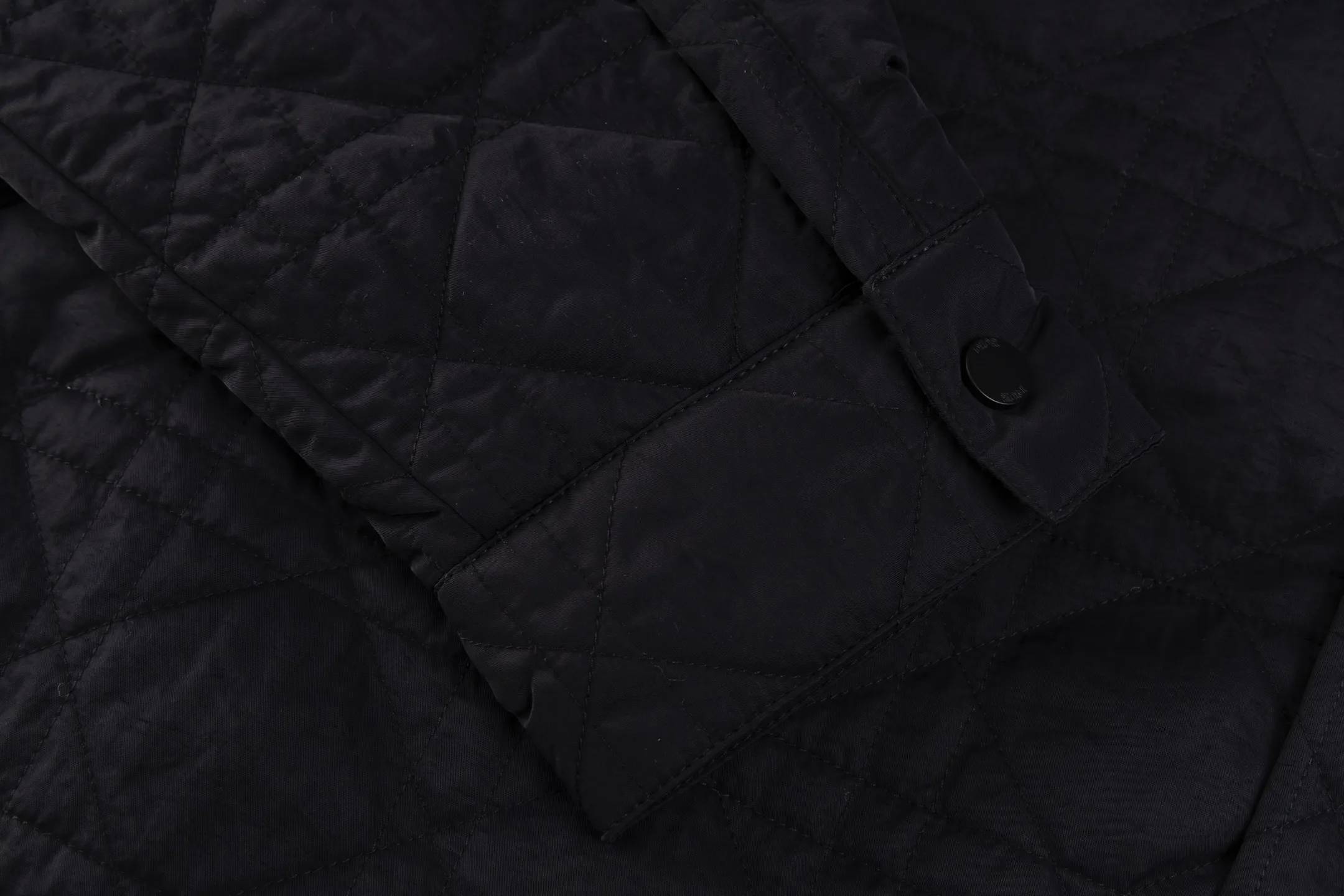 🅿️720 [Exclusive supply] CD Cannage nameplate embroidered jacket. The original version was purchased for 23,000 and developed. The fabric is made of polyester fiber technical fabric, which has both light texture and crisp silhouette. The whole body is quilted in the same tone to present the brand's iconic cannage pattern, and the details are full of exquisite craftsmanship. The chest patch pocket is decorated with an embroidered Christian Dior Couture logo, highlighting the brand's DNA. Side slits and metal snaps engraved with the Dior logo allow you to adjust the style of wearing. The overall tailoring is neat and smooth, perfectly combining traditional quilting technology with modern technological fabrics. The black tone presents a low-key luxury feel, and the cannage quilting lines are delicate and even, showing the craftsmanship of high-end ready-to-wear. This piece can be worn open for a casual style, or fastened with snaps for a slim fit, making it perfect for a variety of dressing scenarios. Size:46/48/50/52