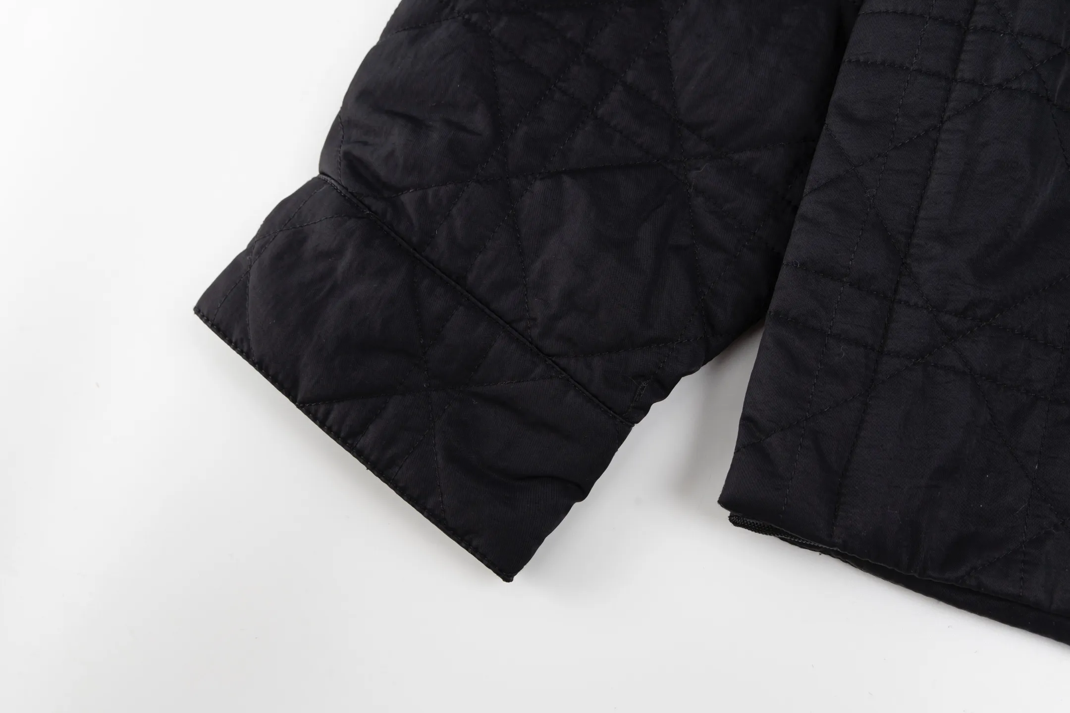 🅿️720 [Exclusive supply] CD Cannage nameplate embroidered jacket. The original version was purchased for 23,000 and developed. The fabric is made of polyester fiber technical fabric, which has both light texture and crisp silhouette. The whole body is quilted in the same tone to present the brand's iconic cannage pattern, and the details are full of exquisite craftsmanship. The chest patch pocket is decorated with an embroidered Christian Dior Couture logo, highlighting the brand's DNA. Side slits and metal snaps engraved with the Dior logo allow you to adjust the style of wearing. The overall tailoring is neat and smooth, perfectly combining traditional quilting technology with modern technological fabrics. The black tone presents a low-key luxury feel, and the cannage quilting lines are delicate and even, showing the craftsmanship of high-end ready-to-wear. This piece can be worn open for a casual style, or fastened with snaps for a slim fit, making it perfect for a variety of dressing scenarios. Size:46/48/50/52