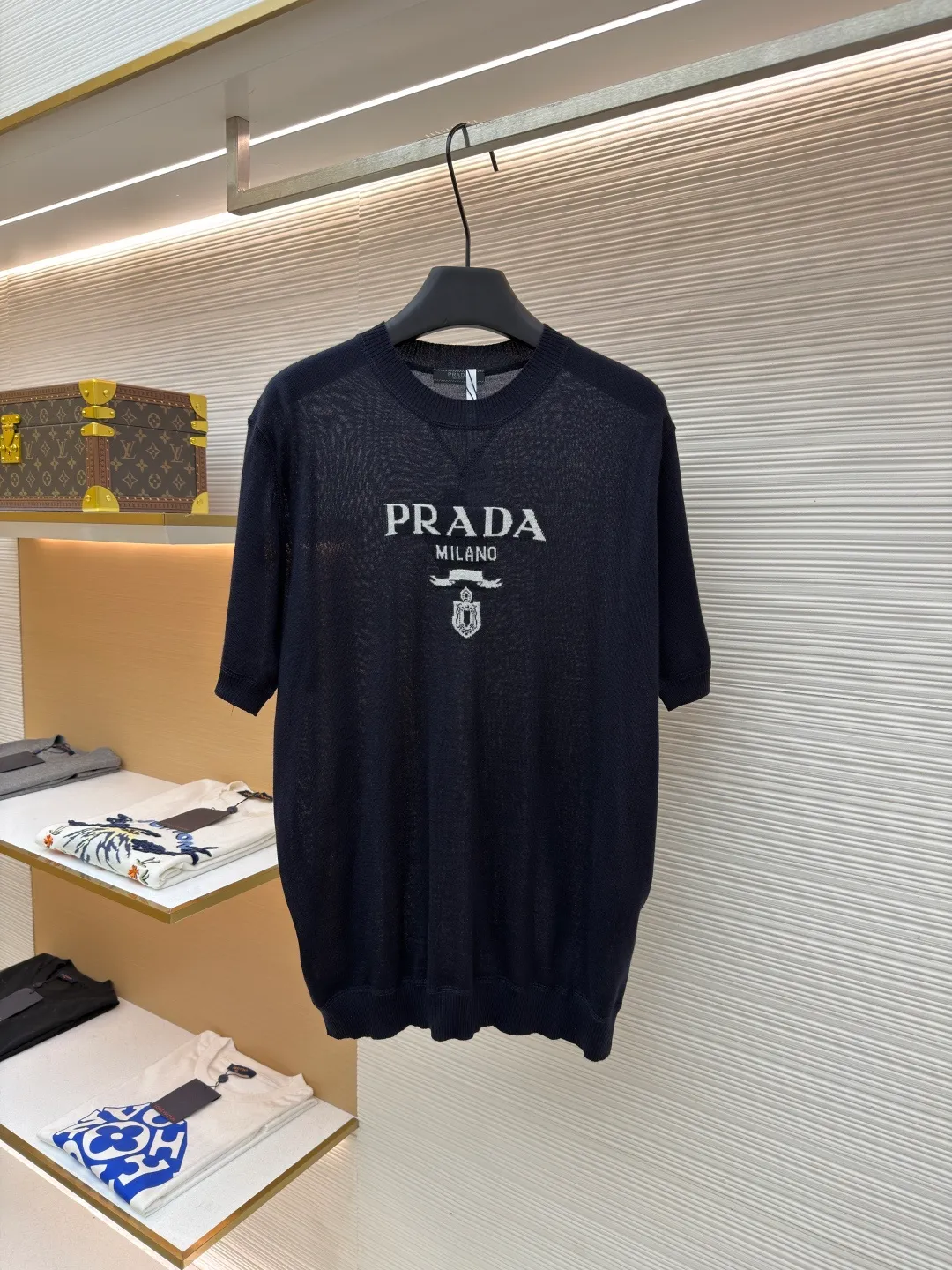 Prada classic LOGO jacquard wool round neck short sleeves ●Original version: purchased and developed by 11988 ●Item number: 1682516-A45 ●Fabric: wool fabric ●Technology: jacquard production ●Color: black ●Version: fitted version ●Weight: about 150 grams ●Size: 46-48-50-52 ●Description: This PRADA gray knitted short-sleeve is woven with high-quality combed cotton threads. The body is made of vertical pit knitting technology. The texture is three-dimensional and elastic. It is soft and breathable when worn next to the skin. It has good drape and stiffness, and is not prone to pilling and deformation. The brand letters and badge pattern on the front of the garment are made with precision embroidery technology. The embroidery thread is made of imported high-gloss yarn. The stitches are dense and even, and the pattern is three-dimensional and clear. It forms a texture contrast with the knitted base to highlight the brand recognition. The neckline is a classic round neck design, with double-needle reinforced hemming technology and a customized threaded collar, which is durable and not easy to loosen. The cuffs and hem are ribbed in the same color. The overall cut is a loose silhouette. The stitching is straight and fine. The customized accessories and three standards are complete. The detailed craftsmanship shows the level of luxury. It is suitable for casual daily and light business wear scenarios. The overall wiring is straight and delicate, the fabric is comfortable and soft, and the color is consistent without color difference. It can be matched with the same style to create a fashionable look and control various occasions. Customized accessories, complete with three standards, same style for men and women!