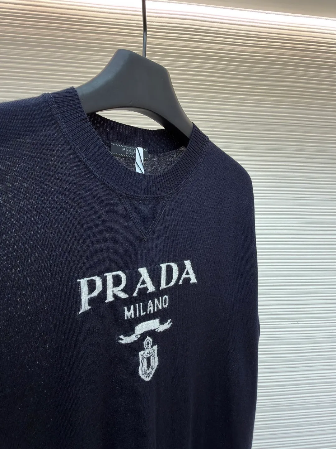 Prada classic LOGO jacquard wool round neck short sleeves ●Original version: purchased and developed by 11988 ●Item number: 1682516-A45 ●Fabric: wool fabric ●Technology: jacquard production ●Color: black ●Version: fitted version ●Weight: about 150 grams ●Size: 46-48-50-52 ●Description: This PRADA gray knitted short-sleeve is woven with high-quality combed cotton threads. The body is made of vertical pit knitting technology. The texture is three-dimensional and elastic. It is soft and breathable when worn next to the skin. It has good drape and stiffness, and is not prone to pilling and deformation. The brand letters and badge pattern on the front of the garment are made with precision embroidery technology. The embroidery thread is made of imported high-gloss yarn. The stitches are dense and even, and the pattern is three-dimensional and clear. It forms a texture contrast with the knitted base to highlight the brand recognition. The neckline is a classic round neck design, with double-needle reinforced hemming technology and a customized threaded collar, which is durable and not easy to loosen. The cuffs and hem are ribbed in the same color. The overall cut is a loose silhouette. The stitching is straight and fine. The customized accessories and three standards are complete. The detailed craftsmanship shows the level of luxury. It is suitable for casual daily and light business wear scenarios. The overall wiring is straight and delicate, the fabric is comfortable and soft, and the color is consistent without color difference. It can be matched with the same style to create a fashionable look and control various occasions. Customized accessories, complete with three standards, same style for men and women!