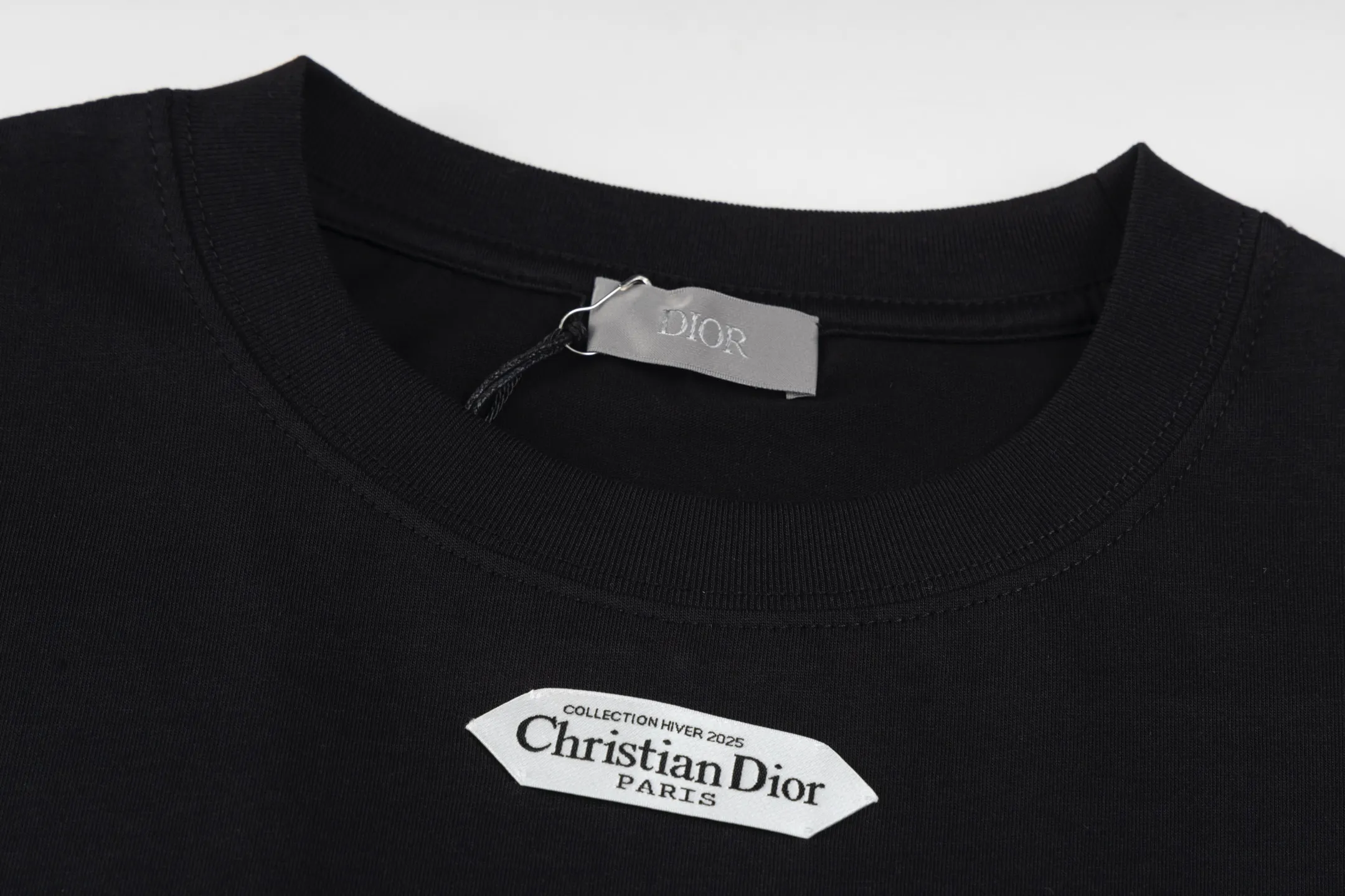 🅿️280 [Exclusive supply] CD 25FW simple label short sleeves (black) The fabric is made of 24S 185g special woven compact cotton fabric, and the rib is made of 32S 300g double yarn rib. This T-shirt is new to the 2025 winter men's collection. It is decorated with a CD Paris logo label inspired by the spirit of haute couture to enhance the style and pay tribute to the extraordinary craftsmanship of the workshop. Crafted from black cotton jersey with a ribbed crew neck and cuffs, it can be worn with track pants for a casual look. It is woven with 24-count special compact cotton yarn. The weaving process requires high standards and requires the use of advanced looms and high-quality raw materials. Specially woven compact cotton has many advantages, such as softness and comfort, good breathability, strong wrinkle resistance, good durability, etc.; it has a tighter, softer and more delicate texture and feel. The brand label on the chest is embellished as the brand's signature detail and is woven using double-sided jacquard technology; black threads are embedded in the white base, or micro-letters are formed through the density of the yarn. The edge of the label is processed by laser cutting, and there are no defects such as yarn leakage and yarn leakage. Size:XS/S/M/L