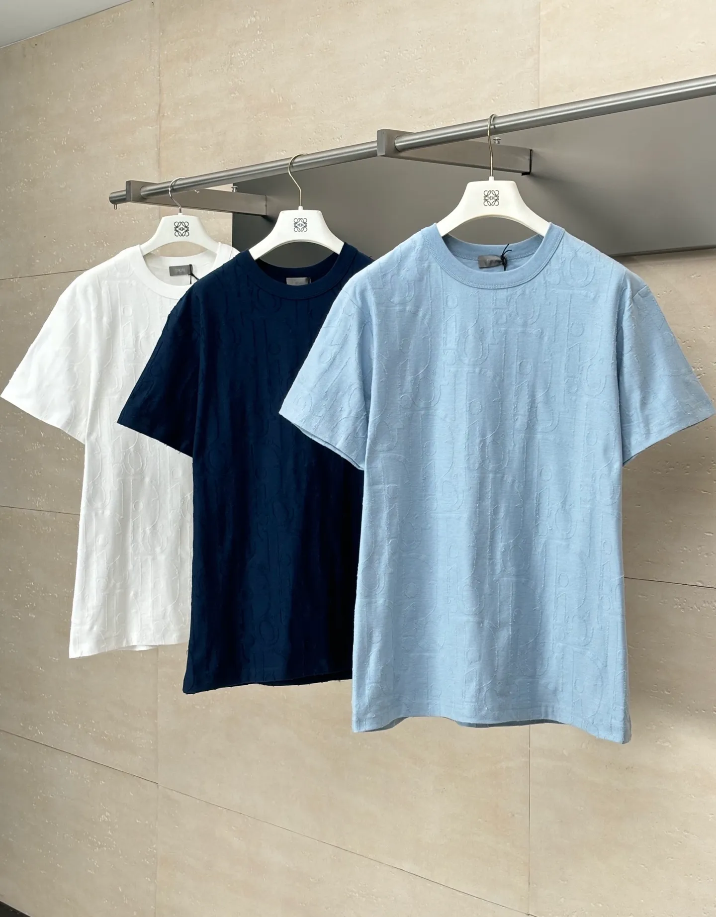 🅿️296 Dio*/Dior 25Ss new line-cut jacquard round-neck short-sleeved T-shirt. Pure cotton plain weave fabric, woven with 32S double-ply pure cotton yarn. The fabric has high abrasion resistance while retaining the moisture absorption and breathability of pure cotton. The plain weave has a tight structure and a smooth surface, but it feels relatively stiff and supports the stiffness of the version. Jacquard pattern, line-cut jacquard technology, full-width Oblique jacquard pattern The relief effect is formed through the deep integration of full-width jacquard and shearing process. The jacquard structure provides a three-dimensional skeleton, and the shearing process strengthens the local texture. Electronic jacquard machine weaves complex patterns on the entire fabric, forming a three-dimensional concave and convex texture to achieve the integration of texture and pattern. The raised jacquard is directionally sheared to form a relief effect, enhancing the tactile level and visual contrast. Size: S/M/L/XL
