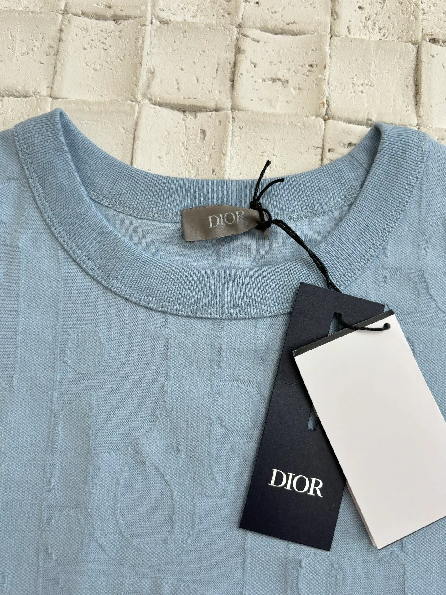 🅿️296 Dio*/Dior 25Ss new line-cut jacquard round-neck short-sleeved T-shirt. Pure cotton plain weave fabric, woven with 32S double-ply pure cotton yarn. The fabric has high abrasion resistance while retaining the moisture absorption and breathability of pure cotton. The plain weave has a tight structure and a smooth surface, but it feels relatively stiff and supports the stiffness of the version. Jacquard pattern, line-cut jacquard technology, full-width Oblique jacquard pattern The relief effect is formed through the deep integration of full-width jacquard and shearing process. The jacquard structure provides a three-dimensional skeleton, and the shearing process strengthens the local texture. Electronic jacquard machine weaves complex patterns on the entire fabric, forming a three-dimensional concave and convex texture to achieve the integration of texture and pattern. The raised jacquard is directionally sheared to form a relief effect, enhancing the tactile level and visual contrast. Size: S/M/L/XL