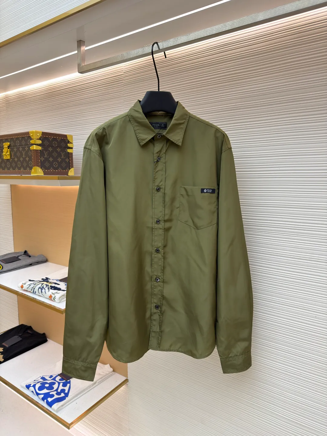 Prada triangle emblem label shirt ●Original version: Purchased and developed by 8100 ●Item number: 1682563-A75 ●Fabric: Regenerated nylon fabric ●Technology: Silk double yarn interweaving ●Color: Green ●Version: Fitted version ●Weight: about 180 grams ●Size: 39-40-41-42 ●Description: Custom dyed regenerated nylon material feels like the end of the world technology, light and tough, comfortable and close to the skin Military green is used to construct the wild sense and order of workwear aesthetics. The Prada logo label is embellished on the chest patch pocket and complements the triangular logo on the back fabric to express the brand identity. The slightly wide shoulder line and curved hem form an architectural-level silhouette. The visual aristocratic gene, minimalism and luxury coexist, interpreting high-end fashion style. Silk double yarn interweaving processing technology uses nano-imprint technology to build honeycomb-shaped protrusions on the surface of the fabric, and then uses high temperature and high pressure to form covalent bonds between fluorine atoms and nylon fibers, forming a micro-matte film layer on the surface to prevent oil stains from reducing the waterproof performance. Three-dimensional cutting of the human body returns to traditional craftsmanship through segmentation, folding, shrinking, and stretching techniques. The so-called slow work produces fine work, which is the respect for materials and the pursuit of feel. The workmanship is complex and tedious, slow in aging, and high in loss. The overall wiring is straight and delicate, the fabric is comfortable and soft, and the color is consistent without color difference. It can be matched with the same style to create a fashionable look and control various occasions. Customized accessories, complete with three standards, same style for men and women!
