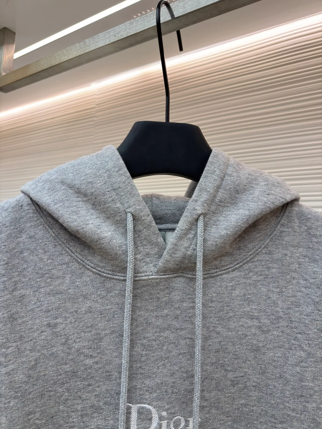 Dior classic logo embroidered hooded sweatshirt ●Item number: 1682332-A75 ●Material: cotton fabric ●Technology: embroidery production ●Color: gray ●Version: fitted version ●Weight: about 645 grams ●Size: XS-S-M-L ●Description: It adopts a fleece fabric structure of 26 counts of double yarn + 10S plush bottom, with a weight of 380g/㎡, and 21 counts of 1x1 ribs with a weight of 470g/㎡. It is used for the cuffs and hem. Its extremely high weight ensures the ultimate thickness, stiffness and deformation resistance of these closing parts, forming a unified and strong outline with the body. The fabric is a heavyweight and high-quality sweatshirt fabric. The 26-count double yarn forms a smooth, delicate and strong outer surface of the fabric, ensuring good color fastness and appearance. The 10S plush base undergoes a precise fleece or brushing process to form a layer of rich, dense and uniform fluff on the inside of the fabric. This makes the sweatshirt have a crisp and skeletal feel on the outside and an extremely soft and warm feel on the inside. White tone twill needle embroidery process. Needle embroidery is a straight line embroidery with stitches closely connected and evenly arranged. It is often used to outline clear and sharp outlines. This stitch is used to embroider a diagonal stripe pattern with a certain angle and width. Use white embroidery thread to follow the preset diagonal trajectory and perform precise embroidery with high-density stitches. On the high-weight fabric base, simple, exquisite and three-dimensional line decoration is created. The contrast between white and fabric color is sharp, and the slightly convex texture brought by the embroidery adds a visual and tactile layer, effectively enhancing the exquisite style of the basic sweatshirt. The overall wiring is straight and delicate, the fabric is comfortable and soft, and the color is consistent without color difference. It can be matched with the same style to create a fashionable look and control various occasions. Customized accessories, complete with three standards, same style for men and women!