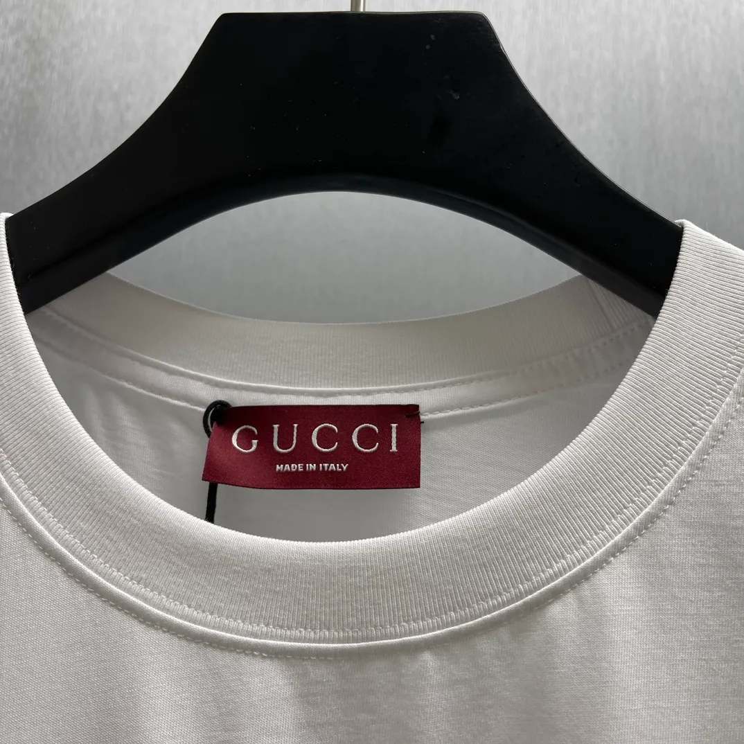 🅿️240 🧧CD Surfer printed knitted cotton T-shirt Size: S-XL The 2025 spring and summer series presents knitted items beautifully embellished with new patterns. Crafted from garment-dyed knitted cotton, this oversized T-shirt is embellished with the Gucci logo print on the front and the Gucci surfer print on the back, adding to the allure of the design.