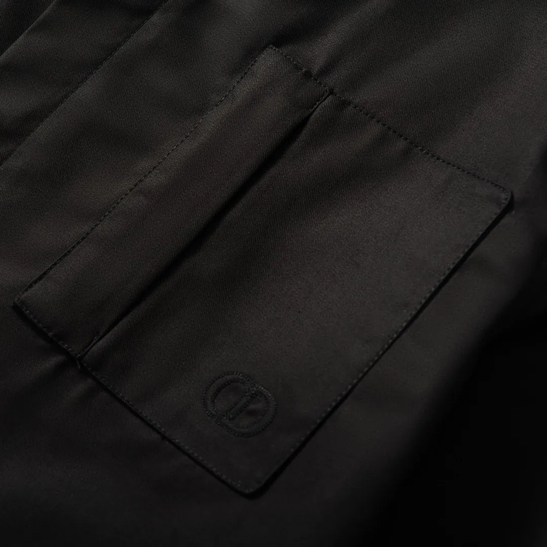 🅿️590 [Exclusive supply] CD icon pocket embroidered lapel jacket. The fabric is made of black gabardine fabric, with a smooth and delicate surface, soft touch, and an elegant sheen. Its tight textile construction makes it resistant to wrinkles, abrasion and drape. The wool component makes it warm and breathable. Gabardine fabric is not easy to pill, has good stain resistance, and is easy to care for daily. The modern fit has a slim fit and a hidden zip closure adds understated sophistication. High-precision sewing technology ensures a perfect fit between the zipper and the fabric. The lapel design of traditional shirts still meets the needs of formal occasions. There is a patch pocket on the chest and is decorated with CD icon embroidery, which highlights the brand's iconic elements. The bag opening also has a hidden zipper opening, and the bag opening is reinforced with pocket knotting technology at the beginning and end. Tight stitching at the edge of the bag body makes it strong and beautiful. There are side pockets on the left and right sides, and the pocket openings are only 0.5 cm hemmed, which retains the smoothness of the overall lines without losing practicality. The double-button design of traditional shirt cuffs makes the cuffs fit more closely on the wrist and prevent them from loosening. Size:46/48/50/52