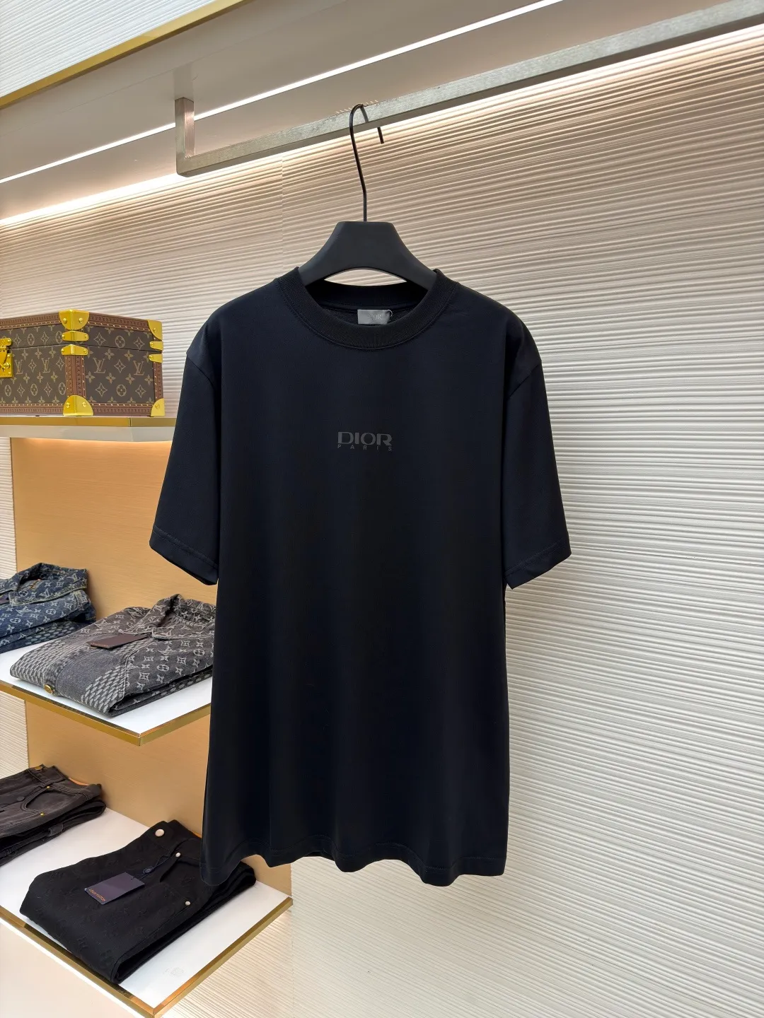 Dior Reflective Triangle Icon Round Neck Short Sleeve ●Original version: Purchased and developed by 6323 ●Item No.: 1681099-A00 ●Fabric: Jersey fabric ●Technology: Reflective lettering and embossed production ●Version: Fitted version ●Weight: about 220 grams ●Size: S-M-L-XL ●Description: The main body is made of 24S special woven compact cotton to make jersey fabric, weight 180g. High-count combed cotton yarn eliminates most of the short hairiness through compact spinning process, making the yarn smoother and stronger. The woven fabric structure is extremely dense, flat and soft, with excellent anti-pilling ability and durability, while retaining the natural advantages of pure cotton, which is breathable and skin-friendly. The neckline is made of 32S 1x1 rib with a weight of 300g. The finer yarn count creates a more delicate and tight thread, which provides better elasticity and deformation resistance than ordinary ribs, ensuring that the neckline can still remain stiff after being put on and taken off many times. The reflective engraving and embossing process is a sophisticated technology that combines safety functions with visual aesthetics. The core is to use a reflective lettering film with a built-in micro-glass bead layer. First, a high-precision laser cutting machine is used to engrave the outline according to the designed fonts and patterns to ensure that the edges are clear and burr-free. The cut reflective film is accurately attached to the surface of the fabric through heat transfer printing equipment under specific temperature and pressure, so that it is firmly combined with the fabric fibers. The case is matte silver-gray under normal conditions, but when illuminated by light, the micro-glass bead layer can achieve efficient retroreflection and instantly present a striking bright effect. The finished product is washable and abrasion resistant, perfectly meeting the dual needs of sportswear for functionality and visual tension. The overall wiring is straight and delicate, the fabric is comfortable and soft, and the color is consistent without color difference. It can be matched with the same style to create a fashionable look and control various occasions. Customized accessories, complete with three standards, same style for men and women!