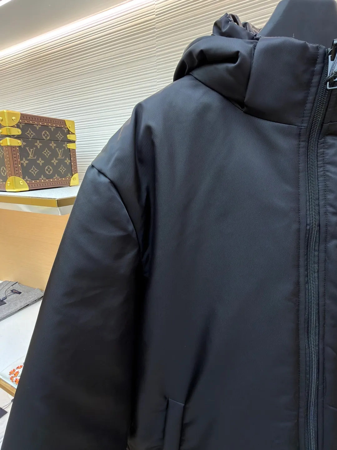 Prada mid-length nylon hooded down jacket ●Original version: purchased and developed for 15999 ●Item number: 1681587-D35 ●Fabric: white duck down fabric ●Technology: mechanical down filling ●Color: black ●Version: fitted version ●Weight: about 1155 grams ●Size: S-M-L-XL ●Description: Re-Nylon short down jacket uses environmentally friendly Re-Nylon material, the fabric density is very high It has strong tear resistance, strong stiffness and wear resistance. It is different from the Bird brand's hard shell, it is softer and has a very strong sense of functionality. Double-sided design: The biggest highlight of this down jacket is its double-sided design, which allows one piece of clothing to show two different styles and shapes, greatly increasing the diversity and fashion sense of wearing. Detachable hood: The down jacket is equipped with a detachable nylon hood, which users can easily remove or install according to weather changes or personal preferences, which is both practical and convenient. The details are exquisitely processed: the zipper design is simple and elegant, easy to operate; the closing design of the cuffs and hem effectively prevents the intrusion of cold wind, improving the warmth and comfort of wearing. All the hangtags, wash marks, air holes, snap buttons, and chest labels are all custom-made using original one-to-one molds.  The overall wiring is straight and delicate, the fabric is comfortable and soft, and the color is consistent without color difference. It can be matched with the same style to create a fashionable look and control various occasions. Customized accessories, complete with three standards, same style for men and women!
