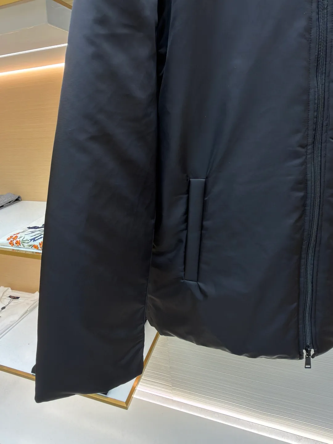 Prada mid-length nylon hooded down jacket ●Original version: purchased and developed for 15999 ●Item number: 1681587-D35 ●Fabric: white duck down fabric ●Technology: mechanical down filling ●Color: black ●Version: fitted version ●Weight: about 1155 grams ●Size: S-M-L-XL ●Description: Re-Nylon short down jacket uses environmentally friendly Re-Nylon material, the fabric density is very high It has strong tear resistance, strong stiffness and wear resistance. It is different from the Bird brand's hard shell, it is softer and has a very strong sense of functionality. Double-sided design: The biggest highlight of this down jacket is its double-sided design, which allows one piece of clothing to show two different styles and shapes, greatly increasing the diversity and fashion sense of wearing. Detachable hood: The down jacket is equipped with a detachable nylon hood, which users can easily remove or install according to weather changes or personal preferences, which is both practical and convenient. The details are exquisitely processed: the zipper design is simple and elegant, easy to operate; the closing design of the cuffs and hem effectively prevents the intrusion of cold wind, improving the warmth and comfort of wearing. All the hangtags, wash marks, air holes, snap buttons, and chest labels are all custom-made using original one-to-one molds.  The overall wiring is straight and delicate, the fabric is comfortable and soft, and the color is consistent without color difference. It can be matched with the same style to create a fashionable look and control various occasions. Customized accessories, complete with three standards, same style for men and women!