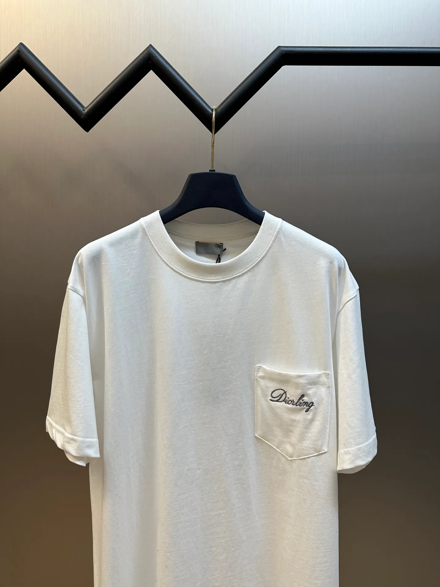 🅿️260 Dior Love Series Pocket Embroidery Round Neck Short Sleeve Cotton Jersey Fabric. Made of 24S special woven compact cotton fabric, 185g; with 32S double yarn thread, 300g. The strength of compact yarn is higher than that of traditional single yarn. The single fibers in compact yarn are closely arranged, which helps to improve the strength of the yarn. The ends of the fibers are all twisted into the yarn, so the yarn is very tight and the yarn has a smooth appearance with less hairiness. Compact spinning yarn has higher strength and less hairiness, making it less prone to fraying.  The chest is decorated with embroidery patterns, and the main body adopts precision stitch embroidery technology; the embroidery is very fine and dense, with clear patterns and strong lines and three-dimensionality. The linen material embroidery thread is combined with encrypted processing, and the embroidery body has a subtle matte visual texture; the embroidery effect is three-dimensional and full. The flat embroidery has a unique needle-to-needle design, and the embroidery is very fine and dense. The overall stitching is fine, with consistent fineness and texture, adding a sense of layering to the simple design.  Standard crew neck, short sleeve fit. The neckline is rounded and arc-shaped, suitable for various face shapes and body shapes; the sleeve length is moderate and ends just above the elbow, showing a smart and neat image. The slim fit can show off the wearer's body curves without sacrificing comfort. The collar, cuffs, hem and other parts are all sewn with fine double-needle stitching.  size：xs s m l