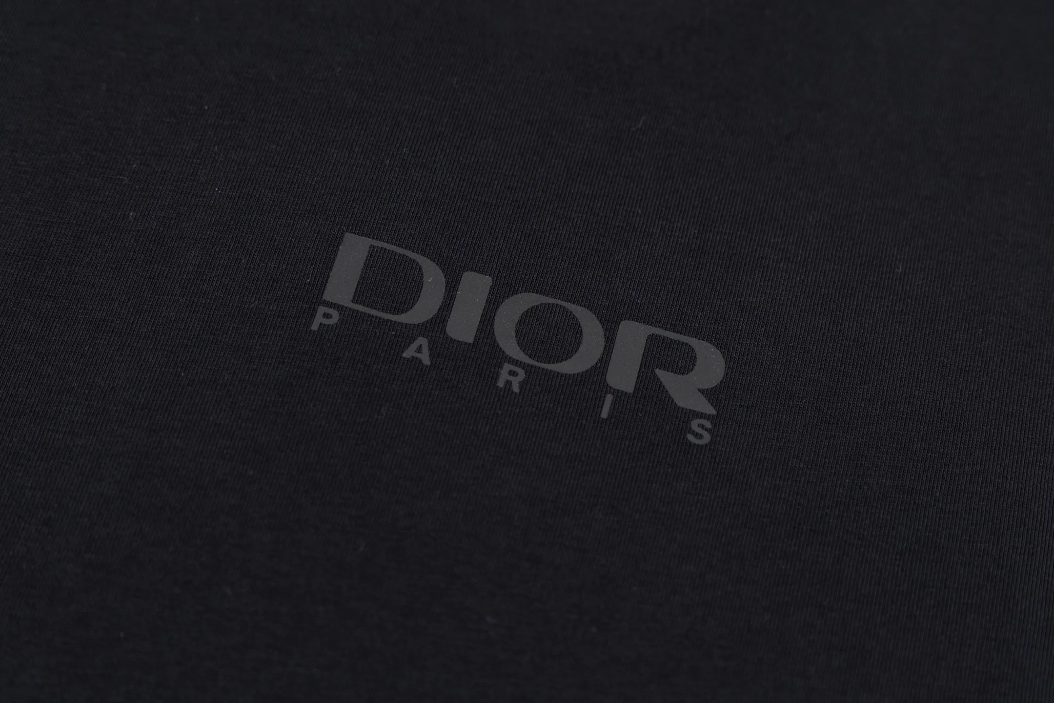 🅿️270 CD AND DESCENT Reflective Printed Short Sleeve (Black) The fabric is made of 24S 185g special woven compact cotton fabric, and the rib is made of 32S 300g double yarn rib. This T-shirt is a new product in the 2026 spring men's wear series, inspired by performance sportswear. Crafted from white cotton jersey with reflective ANDDESCENTE pattern. The ribbed round neck design can be layered with a zippered sweatshirt to create a sophisticated sporty look. The fabric is made of 24S special-spun compact cotton as a plain knitted base. The high-count compact spinning process ensures that the fabric has an extremely delicate skin feel and excellent anti-pilling durability. The neckline is equipped with 32S 1x1 high-density ribbing, which provides long-lasting rebound with its tight structure and protects the collar shape. It uses an advanced laser cutting reflective engraving film thermal transfer process: first, the composite reflective film with built-in micro glass beads is carved out by a high-precision laser cutting machine to create the precise outline of the words; the imprint is positioned and imprinted through precisely controlled temperature, pressure and time. It ensures the sharp and clear edges of the pattern and gives the item unique dynamic visual attributes. Under daily light, it presents a low-key silver-gray color, but when exposed to light in a dark place, it instantly bursts out with strong retroreflection. Through innovative reflective technology and sophisticated basic materials, performance is transformed into a perceptible visual language. Size:XS-S-M-L