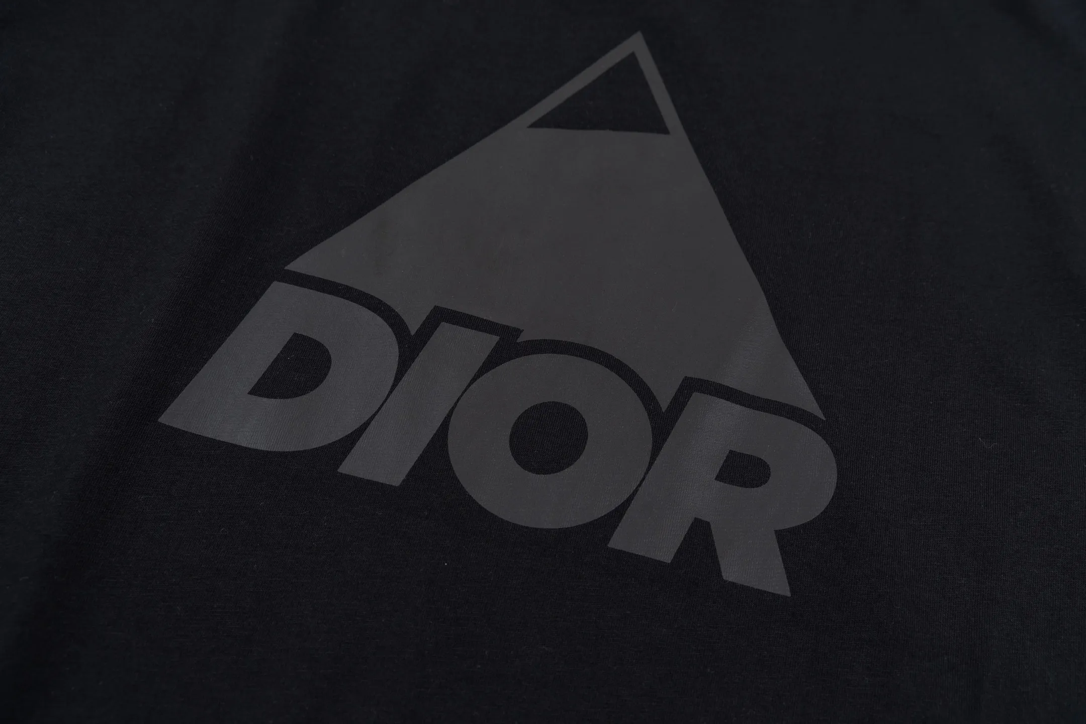 🅿️270 CD AND DESCENT Reflective Printed Short Sleeve (Black) The fabric is made of 24S 185g special woven compact cotton fabric, and the rib is made of 32S 300g double yarn rib. This T-shirt is a new product in the 2026 spring men's wear series, inspired by performance sportswear. Crafted from white cotton jersey with reflective ANDDESCENTE pattern. The ribbed round neck design can be layered with a zippered sweatshirt to create a sophisticated sporty look. The fabric is made of 24S special-spun compact cotton as a plain knitted base. The high-count compact spinning process ensures that the fabric has an extremely delicate skin feel and excellent anti-pilling durability. The neckline is equipped with 32S 1x1 high-density ribbing, which provides long-lasting rebound with its tight structure and protects the collar shape. It uses an advanced laser cutting reflective engraving film thermal transfer process: first, the composite reflective film with built-in micro glass beads is carved out by a high-precision laser cutting machine to create the precise outline of the words; the imprint is positioned and imprinted through precisely controlled temperature, pressure and time. It ensures the sharp and clear edges of the pattern and gives the item unique dynamic visual attributes. Under daily light, it presents a low-key silver-gray color, but when exposed to light in a dark place, it instantly bursts out with strong retroreflection. Through innovative reflective technology and sophisticated basic materials, performance is transformed into a perceptible visual language. Size:XS-S-M-L