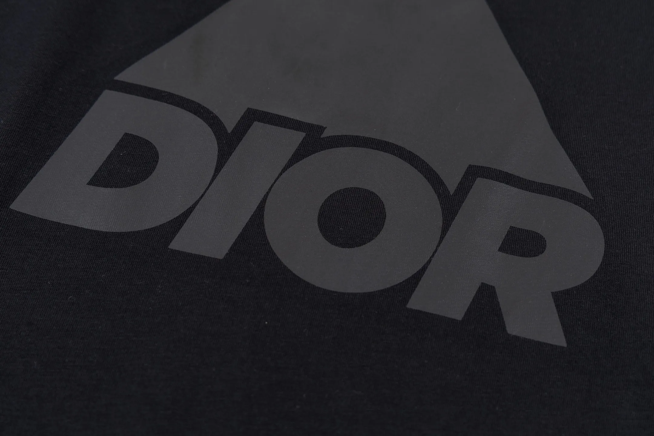 🅿️270 CD AND DESCENT Reflective Printed Short Sleeve (Black) The fabric is made of 24S 185g special woven compact cotton fabric, and the rib is made of 32S 300g double yarn rib. This T-shirt is a new product in the 2026 spring men's wear series, inspired by performance sportswear. Crafted from white cotton jersey with reflective ANDDESCENTE pattern. The ribbed round neck design can be layered with a zippered sweatshirt to create a sophisticated sporty look. The fabric is made of 24S special-spun compact cotton as a plain knitted base. The high-count compact spinning process ensures that the fabric has an extremely delicate skin feel and excellent anti-pilling durability. The neckline is equipped with 32S 1x1 high-density ribbing, which provides long-lasting rebound with its tight structure and protects the collar shape. It uses an advanced laser cutting reflective engraving film thermal transfer process: first, the composite reflective film with built-in micro glass beads is carved out by a high-precision laser cutting machine to create the precise outline of the words; the imprint is positioned and imprinted through precisely controlled temperature, pressure and time. It ensures the sharp and clear edges of the pattern and gives the item unique dynamic visual attributes. Under daily light, it presents a low-key silver-gray color, but when exposed to light in a dark place, it instantly bursts out with strong retroreflection. Through innovative reflective technology and sophisticated basic materials, performance is transformed into a perceptible visual language. Size:XS-S-M-L