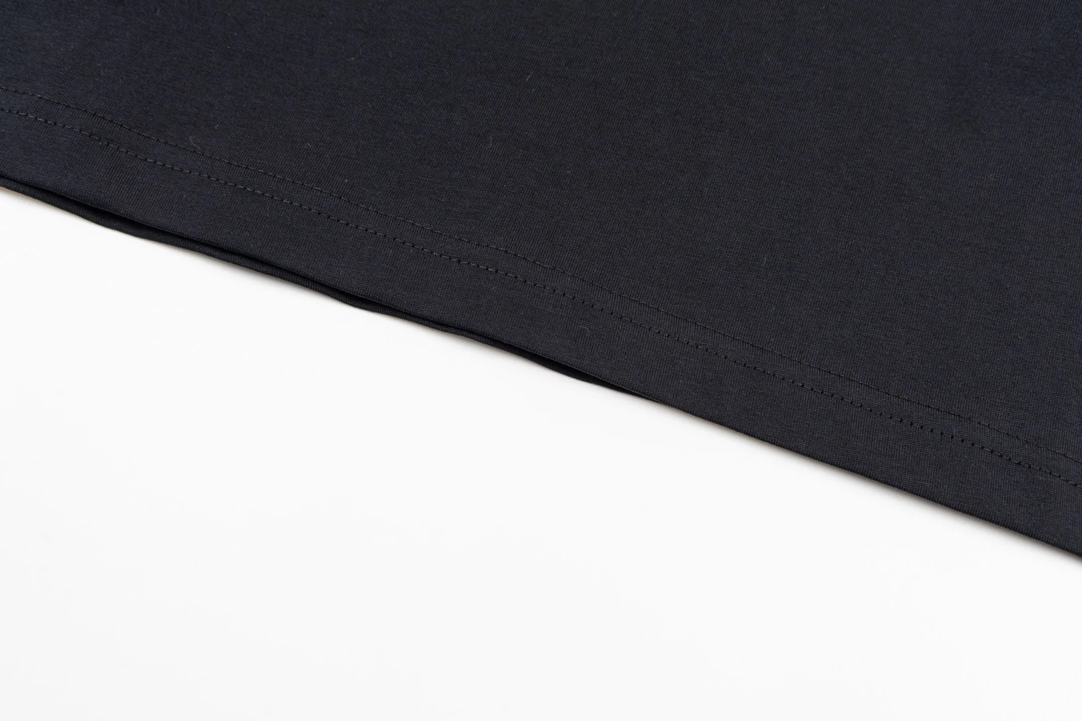🅿️270 CD AND DESCENT Reflective Printed Short Sleeve (Black) The fabric is made of 24S 185g special woven compact cotton fabric, and the rib is made of 32S 300g double yarn rib. This T-shirt is a new product in the 2026 spring men's wear series, inspired by performance sportswear. Crafted from white cotton jersey with reflective ANDDESCENTE pattern. The ribbed round neck design can be layered with a zippered sweatshirt to create a sophisticated sporty look. The fabric is made of 24S special-spun compact cotton as a plain knitted base. The high-count compact spinning process ensures that the fabric has an extremely delicate skin feel and excellent anti-pilling durability. The neckline is equipped with 32S 1x1 high-density ribbing, which provides long-lasting rebound with its tight structure and protects the collar shape. It uses an advanced laser cutting reflective engraving film thermal transfer process: first, the composite reflective film with built-in micro glass beads is carved out by a high-precision laser cutting machine to create the precise outline of the words; the imprint is positioned and imprinted through precisely controlled temperature, pressure and time. It ensures the sharp and clear edges of the pattern and gives the item unique dynamic visual attributes. Under daily light, it presents a low-key silver-gray color, but when exposed to light in a dark place, it instantly bursts out with strong retroreflection. Through innovative reflective technology and sophisticated basic materials, performance is transformed into a perceptible visual language. Size:XS-S-M-L