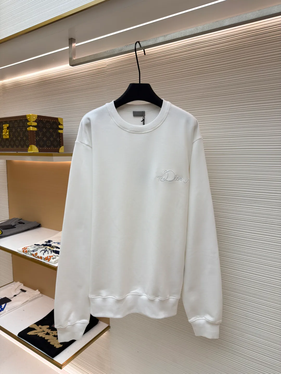 Dior woven satin badge crew neck sweatshirt ●Original version: Purchased and developed by 9976 ●Item number: 1681701-A60 ●Fabric: cotton fleece terry fabric ●Technology: embroidery production ●Color: white ●Version: fitted version ●Weight: about 575 grams ●Size: XS-S-M-L ●Description: The pure cotton texture fabric is made of 26-count double yarn + 10-count base yarn terry fabric, with a weight of 380g/㎡; it is matched with 21-count 2x2 rib, and the composition is 95% cotton and 5% spandex; the weight is 380g/㎡. The 26-count double yarn is used as the surface yarn, and the yarn is thinner, ensuring the delicate and smooth appearance of the fabric and good color fastness; while the 10-count bottom yarn is used as the terry yarn, and the yarn is thicker, forming loose loops during weaving. After unified raising or brushing treatment in the later stage, a layer of rich, dense and soft velvet is formed on the inside of the fabric. The high weight gives the sweatshirt a heavy drape and crisp texture, making it less prone to wrinkles and with stronger styling capabilities. The pure cotton material ensures excellent breathability, moisture absorption and skin-friendly feel, and the final white color appears pure and rich in texture. The overall wiring is straight and delicate, the fabric is comfortable and soft, and the color is consistent without color difference. It can be matched with the same style to create a fashionable look and control various occasions. Customized accessories, complete with three standards, same style for men and women!