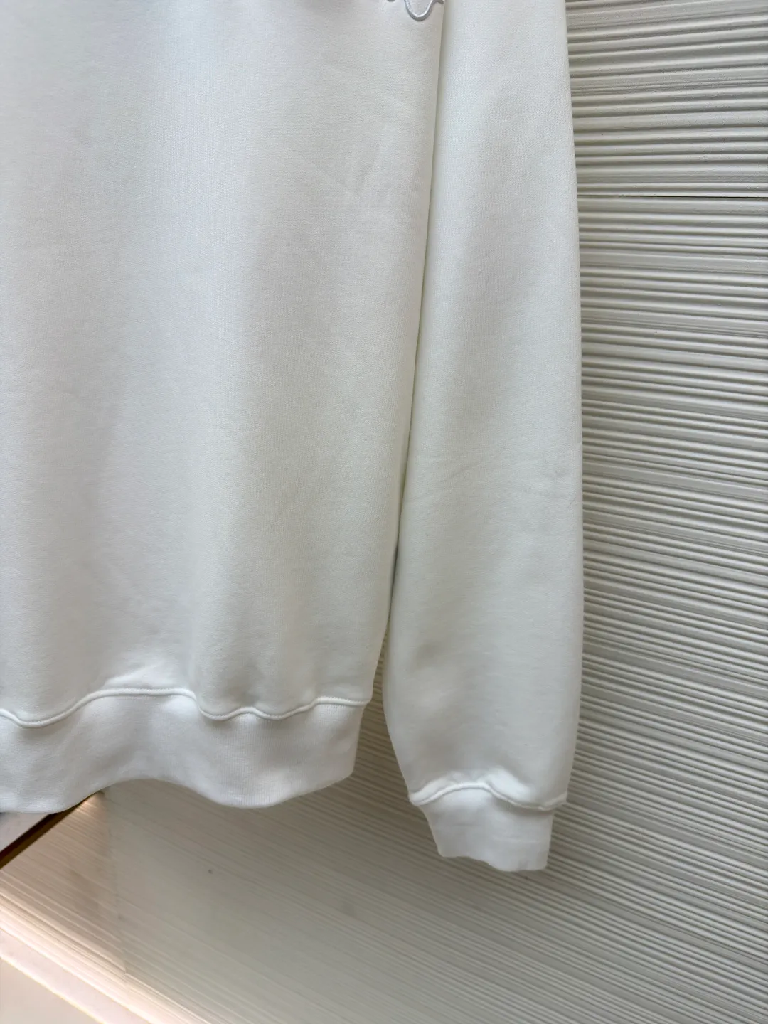 Dior woven satin badge crew neck sweatshirt ●Original version: Purchased and developed by 9976 ●Item number: 1681701-A60 ●Fabric: cotton fleece terry fabric ●Technology: embroidery production ●Color: white ●Version: fitted version ●Weight: about 575 grams ●Size: XS-S-M-L ●Description: The pure cotton texture fabric is made of 26-count double yarn + 10-count base yarn terry fabric, with a weight of 380g/㎡; it is matched with 21-count 2x2 rib, and the composition is 95% cotton and 5% spandex; the weight is 380g/㎡. The 26-count double yarn is used as the surface yarn, and the yarn is thinner, ensuring the delicate and smooth appearance of the fabric and good color fastness; while the 10-count bottom yarn is used as the terry yarn, and the yarn is thicker, forming loose loops during weaving. After unified raising or brushing treatment in the later stage, a layer of rich, dense and soft velvet is formed on the inside of the fabric. The high weight gives the sweatshirt a heavy drape and crisp texture, making it less prone to wrinkles and with stronger styling capabilities. The pure cotton material ensures excellent breathability, moisture absorption and skin-friendly feel, and the final white color appears pure and rich in texture. The overall wiring is straight and delicate, the fabric is comfortable and soft, and the color is consistent without color difference. It can be matched with the same style to create a fashionable look and control various occasions. Customized accessories, complete with three standards, same style for men and women!