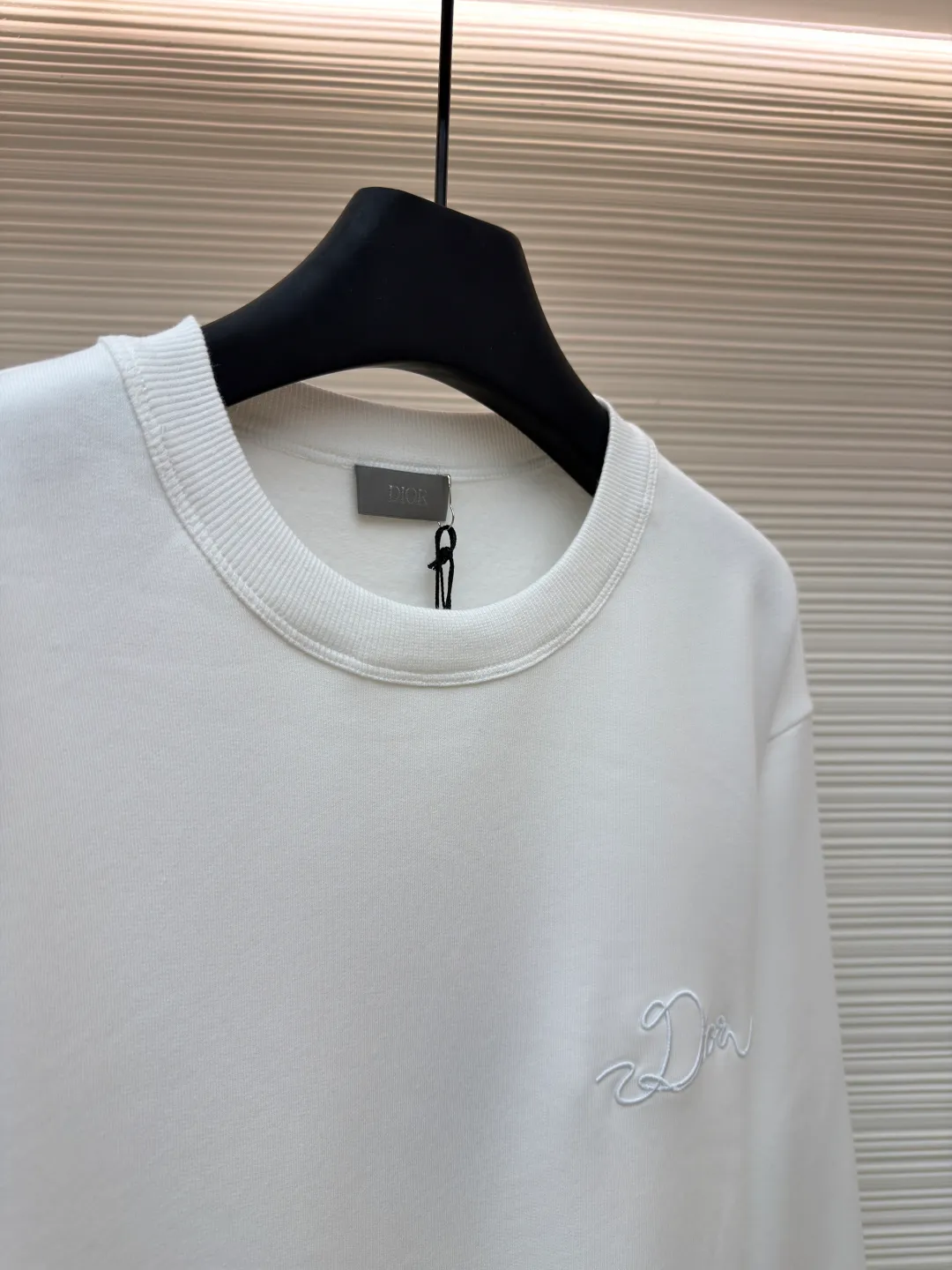 Dior woven satin badge crew neck sweatshirt ●Original version: Purchased and developed by 9976 ●Item number: 1681701-A60 ●Fabric: cotton fleece terry fabric ●Technology: embroidery production ●Color: white ●Version: fitted version ●Weight: about 575 grams ●Size: XS-S-M-L ●Description: The pure cotton texture fabric is made of 26-count double yarn + 10-count base yarn terry fabric, with a weight of 380g/㎡; it is matched with 21-count 2x2 rib, and the composition is 95% cotton and 5% spandex; the weight is 380g/㎡. The 26-count double yarn is used as the surface yarn, and the yarn is thinner, ensuring the delicate and smooth appearance of the fabric and good color fastness; while the 10-count bottom yarn is used as the terry yarn, and the yarn is thicker, forming loose loops during weaving. After unified raising or brushing treatment in the later stage, a layer of rich, dense and soft velvet is formed on the inside of the fabric. The high weight gives the sweatshirt a heavy drape and crisp texture, making it less prone to wrinkles and with stronger styling capabilities. The pure cotton material ensures excellent breathability, moisture absorption and skin-friendly feel, and the final white color appears pure and rich in texture. The overall wiring is straight and delicate, the fabric is comfortable and soft, and the color is consistent without color difference. It can be matched with the same style to create a fashionable look and control various occasions. Customized accessories, complete with three standards, same style for men and women!
