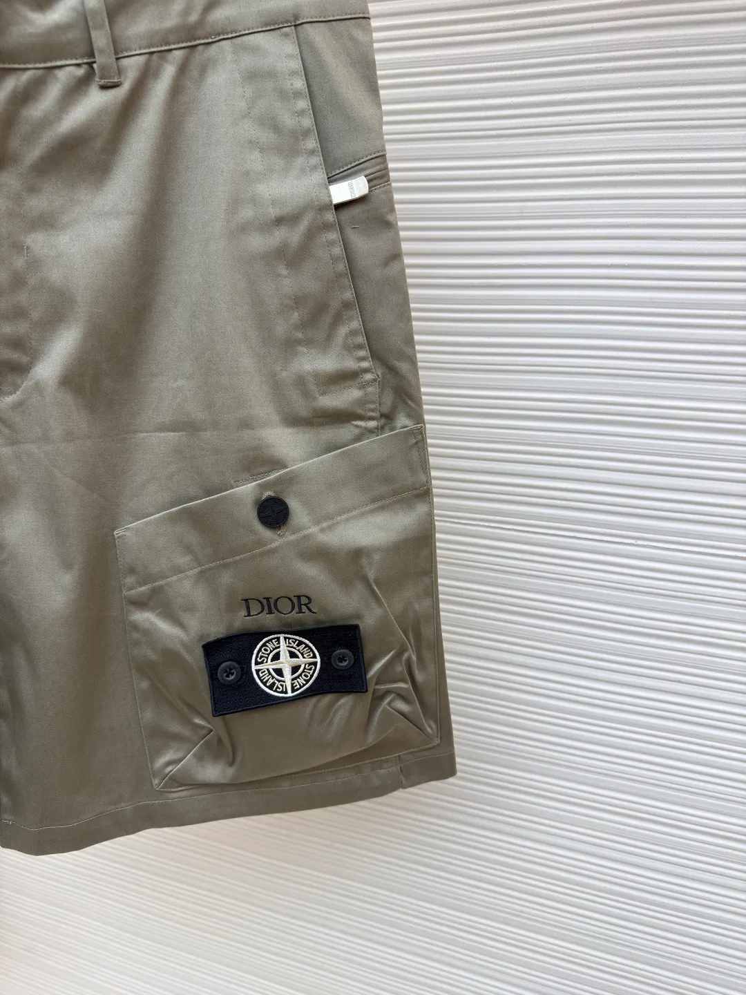 Dior Stone Island co-branded shorts ●Original version: purchased and developed for 21000 ●Item number: 1681492-B70 ●Fabric: cotton high-density twill satin fabric ●Technology: made by rubber coating ●Color: light khaki ●Version: fitted version ●Weight: about 390 grams ●Size: 44-46-48-50 ●Description: The fabric is made of [60s cotton high-density twill satin fabric], [5A grade long-staple cotton yarn], [warp and weft density 200*120], purchased Y version and printed AB color to confirm the dye formula, [custom-dyed bulk fabric color], using [2C thickness TPU hot melt adhesive film], round shaft [glue coating process], high count [ Satin fabric] plus [adhesive film to keep the fabric] 3D three-dimensional, [cool coating] can absorb moisture and perspire, [mold customization with logo rotating puller], [5# platinum corn teeth closed tail zipper], [mould customization silicone cylindrical buckle], the bag is made of [domestic high-speed machine embroidered small logo letters + grid flat embroidered seal]. The overall wiring is straight and delicate, the fabric is comfortable and soft, and the color is consistent without color difference. It can be matched with the same style to create a fashionable look and control various occasions. Customized accessories, complete with three standards, same style for men and women!