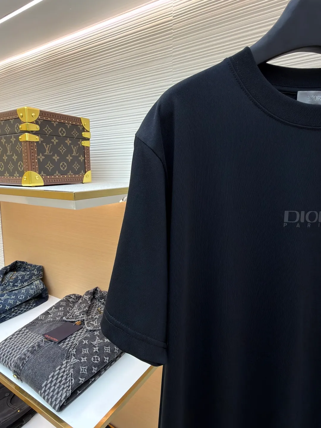 Dior Reflective Triangle Icon Round Neck Short Sleeve ●Original version: Purchased and developed by 6323 ●Item No.: 1681099-A00 ●Fabric: Jersey fabric ●Technology: Reflective lettering and embossed production ●Version: Fitted version ●Weight: about 220 grams ●Size: S-M-L-XL ●Description: The main body is made of 24S special woven compact cotton to make jersey fabric, weight 180g. High-count combed cotton yarn eliminates most of the short hairiness through compact spinning process, making the yarn smoother and stronger. The woven fabric structure is extremely dense, flat and soft, with excellent anti-pilling ability and durability, while retaining the natural advantages of pure cotton, which is breathable and skin-friendly. The neckline is made of 32S 1x1 rib with a weight of 300g. The finer yarn count creates a more delicate and tight thread, which provides better elasticity and deformation resistance than ordinary ribs, ensuring that the neckline can still remain stiff after being put on and taken off many times. The reflective engraving and embossing process is a sophisticated technology that combines safety functions with visual aesthetics. The core is to use a reflective lettering film with a built-in micro-glass bead layer. First, a high-precision laser cutting machine is used to engrave the outline according to the designed fonts and patterns to ensure that the edges are clear and burr-free. The cut reflective film is accurately attached to the surface of the fabric through heat transfer printing equipment under specific temperature and pressure, so that it is firmly combined with the fabric fibers. The case is matte silver-gray under normal conditions, but when illuminated by light, the micro-glass bead layer can achieve efficient retroreflection and instantly present a striking bright effect. The finished product is washable and abrasion resistant, perfectly meeting the dual needs of sportswear for functionality and visual tension. The overall wiring is straight and delicate, the fabric is comfortable and soft, and the color is consistent without color difference. It can be matched with the same style to create a fashionable look and control various occasions. Customized accessories, complete with three standards, same style for men and women!