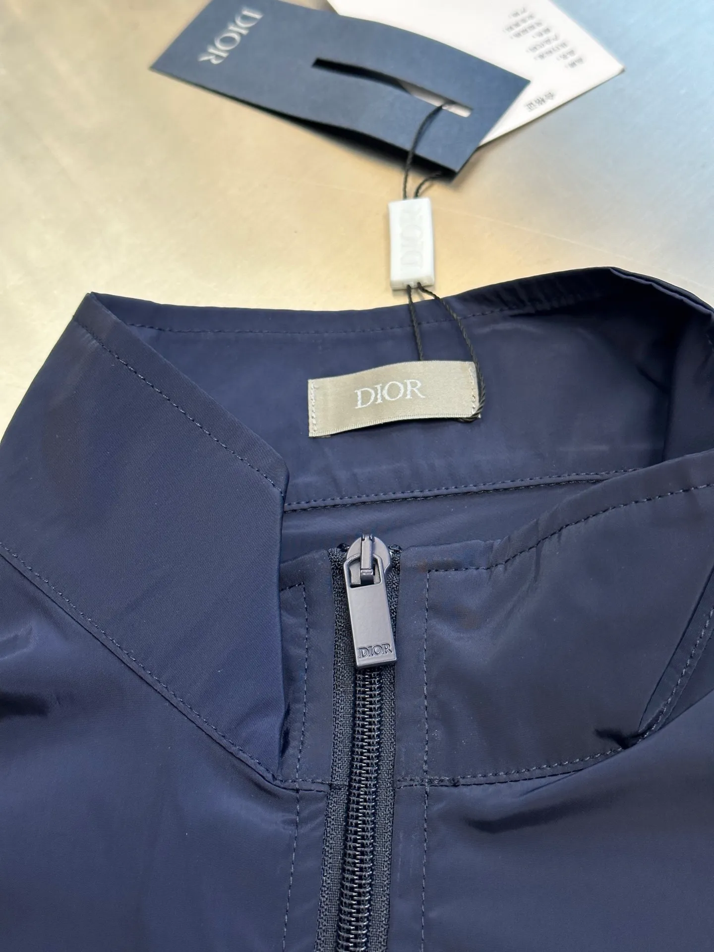 🅿️520 Dior Diamond Logo Zip Jacket Made of custom-made smart functional technical silk fabric, the Dior Diamond logo on the front is presented in a simple and exquisite form, complementing the eye-catching trimmed Dior logo on the back. The stand-up collar design cleverly modifies the neck line, giving it a dynamic elegance.  Infrared positioning heat transfer process, infrared positioning CD Diamond position is more accurate, using thermal transfer material for processing, strong, durable and beautiful.  The template machine opens the bag, and the preset template guides the position, shape and size of the bag. The accuracy ensures the quality of the bag opening effect.  size:50.52.54.56