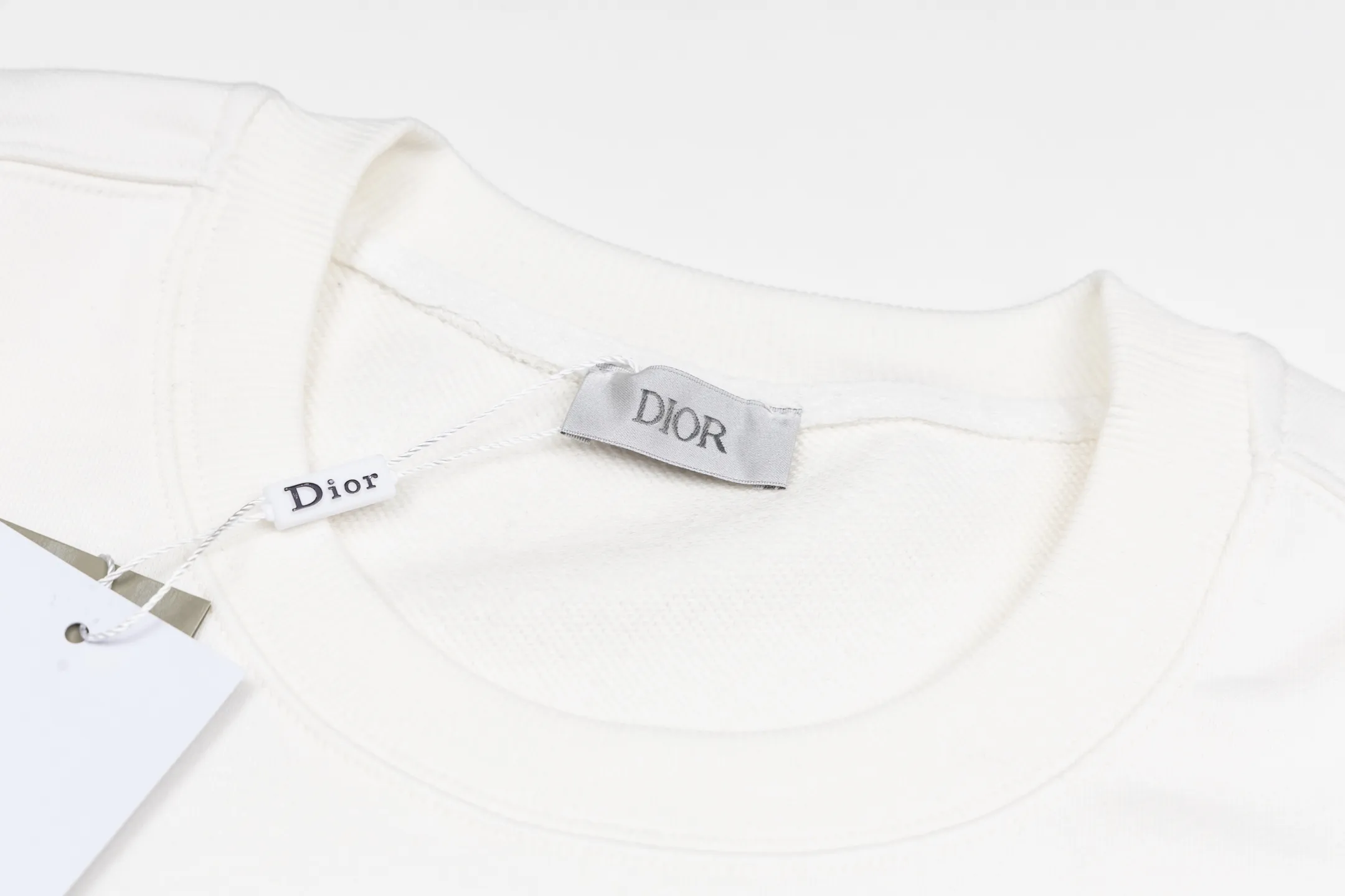 🅿️340 CD logo embroidered crew neck sweatshirt (white) The fabric is made of high-quality white cotton fleece fabric, which is soft and comfortable to the touch, bringing a warm wearing experience. The fabric is made of 100% cotton, which has good breathability and skin-friendliness. The sweatshirt adopts a regular fit design and is discreetly decorated with the same-tone CD Icon embroidery logo on the chest, showing exquisite craftsmanship in every detail. The collar, cuffs and hem are all designed with ribbed edges, which not only enhances the crispness of the overall silhouette, but also keeps the clothing durable and without deformation. Exquisite sewing technology ensures that every seam is smooth and firm, reflecting the brand's strict requirements for quality. This sweatshirt not only retains the comfort of sports and leisure, but also shows the texture of high fashion through exquisite detail processing, making it suitable for daily wear in various occasions. Size:S-M-L-XL