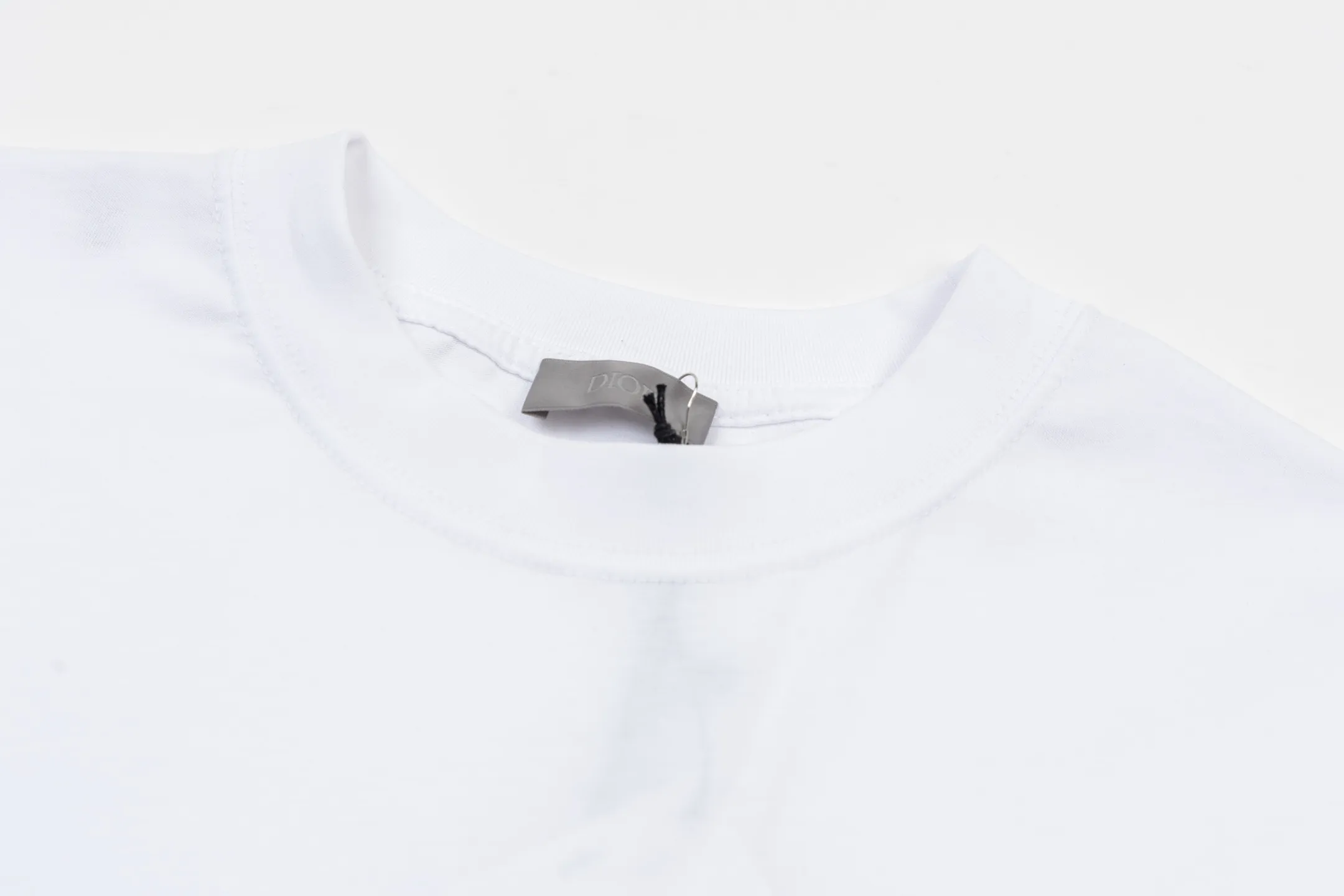 🅿️280 CD Mountain Alpine Shield Printed Short Sleeve (White) The fabric is made of 24S 185g special woven compact cotton fabric, and the rib is made of 32S 300g double yarn rib. This Mountain T-shirt is a new product of the 2026 spring men's wear series. It is decorated with multi-color patches to show the mountain spirit and the classic logo of high-end style inspired by archives. Crafted from white cotton jersey, it features a crew neck for a refined look. The fabric is made of 24S special-spun compact cotton as a plain knitted base. The high-count compact spinning process ensures that the fabric has an extremely delicate skin feel and excellent anti-pilling durability. The neckline is equipped with 32S 1x1 high-density ribbing, which provides long-lasting rebound with its tight structure and protects the collar shape. The decorative multi-color embroidery patch adopts appliqué technique. Three-dimensional lines and fluorescent details are first embroidered with high-density stitches on independent fabrics, and then accurately covered on the chest, forming a strong visual hierarchy and tactile contrast. The alpine element pattern uses digital white ink direct injection technology, with saturated colors and sharp edges, which together with the embroidery patch create a rich texture. Size:XS-S-M-L