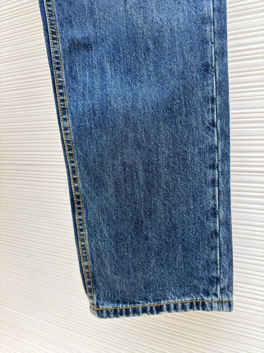 Prada triangle logo jeans ●Original version: Purchased and developed for 10700 ●Item number: 1681036-B20 ●Material: denim denim ●Technology: worn to make The Prada label paper decoration on the back is cleverly integrated. The main color is deep blue, just like the deep night sky. It reveals a luxurious charm in a low-key manner and exudes endless charm. It can easily control various styles. The infrared position of the imported special machine is used to locate the "Prada triangle mark". The position is more accurate and the stone is firmer. Combining rubbing and wrinkling whisker technology with gun-painted whisker technology. Prioritize manual rubbing in specific areas to achieve natural wrinkles. Then use specific tools to draw the texture of the whisker shape. The visual effect is full, and the broken edge hanging technology is used to achieve a natural broken edge effect by physical wear and friction on the edges. Through the combination of high-temperature steam and sandpaper, the fiber hairiness and color difference are removed to give the jeans a unique hole and wear effect. The whole strip is scanned and sprayed. Through the washing process, the color of the entire pair of jeans will have a natural fading effect in parts. The jeans will then be put into the washing equipment for desizing, stone grinding and bleaching to show a uniform fading effect. The dye will be sprayed on the entire denim fabric by a high-pressure pump to achieve the same color tone as the original. The overall wiring is straight and delicate, the fabric is comfortable and soft, and the color is consistent without color difference. It can be matched with the same style to create a fashionable look and control various occasions. Customized accessories, complete with three standards, same style for men and women!