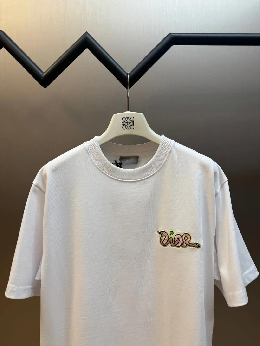 🅿️280 Dior Apple Snake Embroidered Chapter Short Sleeve Made of pure cotton 12S fine cotton plain fabric, 310g. The embroidery pattern is based on tatami embroidery technology. The embroidery uses a special single-needle arrangement. The stitches are tight and flat, forming a texture similar to the tatami grid, making the embroidery pattern have a strong three-dimensional and layered feel. Embroidered with silk threads of multiple colors, the colors are bright and contrasting, showing rich patterns and details.  The outline is stroked by needle embroidery, the embroidery pattern is matched with the brand logo design, and the brand letter logo is single-needle flat embroidered. Made from a variety of needlework; the outline of the pattern is embroidered with a single straight line and straight silk thread. The outline edges and letter embroidery are stitched together to create clear and rich three-dimensional layers.  The standard round neck and short-sleeved version has a rounded arc neckline, which is suitable for various face shapes and body shapes; the sleeve length is moderate and ends just above the elbow, showing a smart and neat image. The slim fit can show off the wearer's body curves without sacrificing comfort. The collar, cuffs, hem and other parts are all sewn with fine double-needle stitching.  size：xs s m l