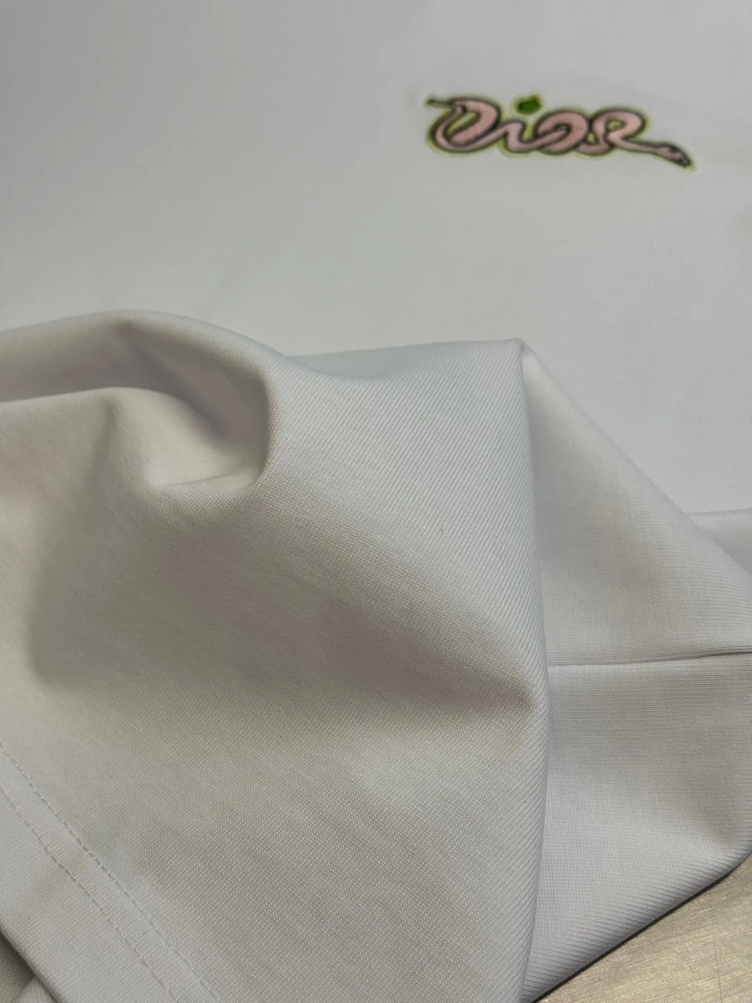 🅿️280 Dior Apple Snake Embroidered Chapter Short Sleeve Made of pure cotton 12S fine cotton plain fabric, 310g. The embroidery pattern is based on tatami embroidery technology. The embroidery uses a special single-needle arrangement. The stitches are tight and flat, forming a texture similar to the tatami grid, making the embroidery pattern have a strong three-dimensional and layered feel. Embroidered with silk threads of multiple colors, the colors are bright and contrasting, showing rich patterns and details.  The outline is stroked by needle embroidery, the embroidery pattern is matched with the brand logo design, and the brand letter logo is single-needle flat embroidered. Made from a variety of needlework; the outline of the pattern is embroidered with a single straight line and straight silk thread. The outline edges and letter embroidery are stitched together to create clear and rich three-dimensional layers.  The standard round neck and short-sleeved version has a rounded arc neckline, which is suitable for various face shapes and body shapes; the sleeve length is moderate and ends just above the elbow, showing a smart and neat image. The slim fit can show off the wearer's body curves without sacrificing comfort. The collar, cuffs, hem and other parts are all sewn with fine double-needle stitching.  size：xs s m l