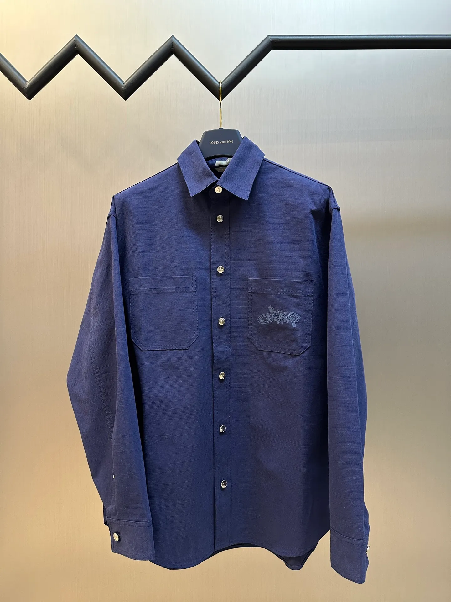 🅿️490 Dior LEWIS HAMILTON Curtain Call Shirt Crafted from blue cotton, it is decorated with patch pockets on the chest, one of which is embellished with tonal co-branded embroidery, reinterpreting the logo in a graphic style. Pair with shorts from the limited collection for a refined look.  Chambray is made of plain weave, which is characterized by interweaving yarn materials of different colors in the warp and weft. It can reflect different levels of light and shade under different light angles, and the colors are rich in changes. The cloth is light and thin in texture, smooth and soft in body, and comfortable to wear. After a specific finishing process, its elasticity and feel are further improved.  Flat stitch embroidery three-dimensional craft is a special embroidery technique that uses flat stitch to create embroidery with a three-dimensional feel. This process creates a richer three-dimensional effect and layering by precisely controlling the depth and angle of the stitches and increasing the density and length.  size:36.38.40.42