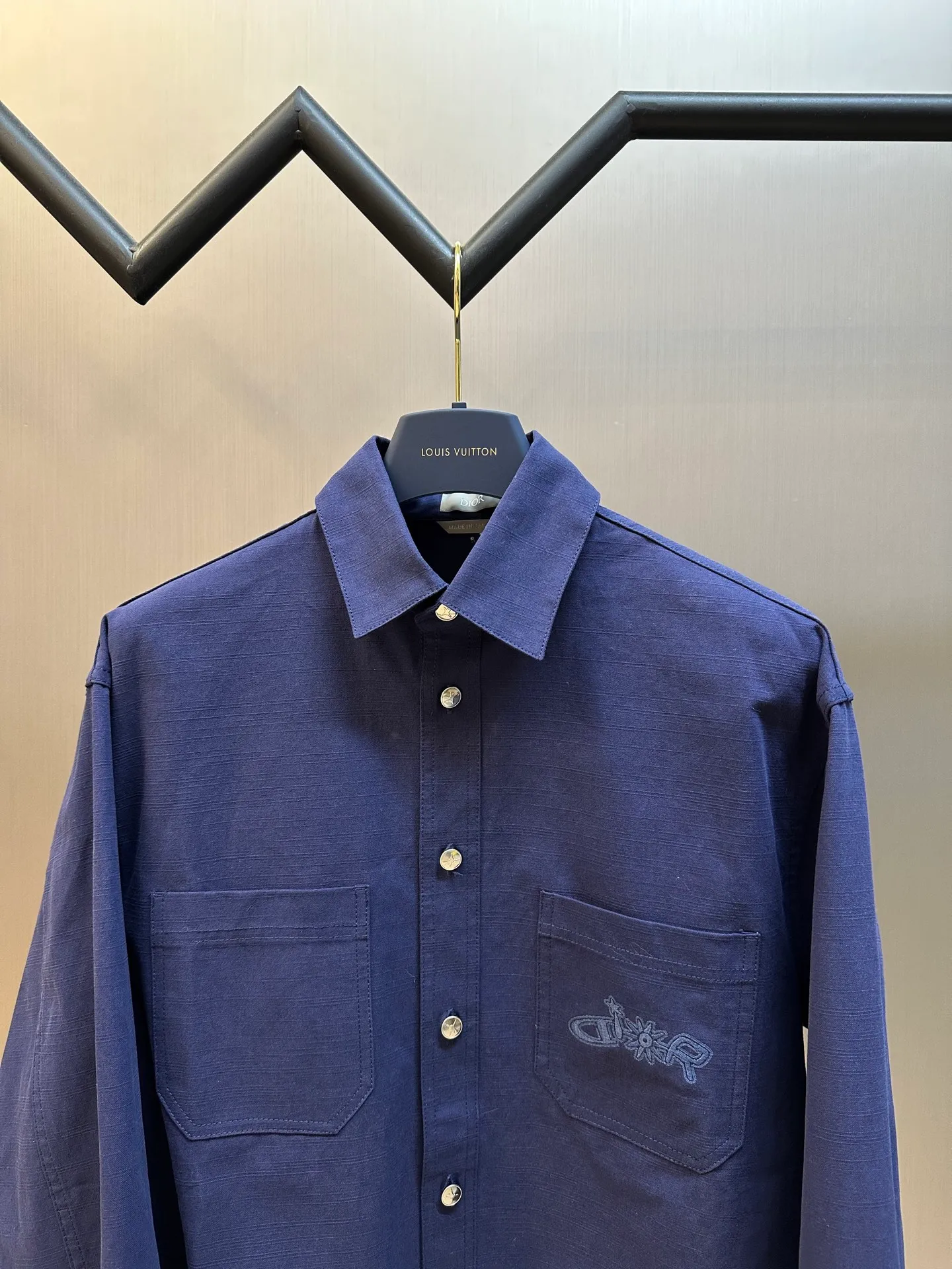 🅿️490 Dior LEWIS HAMILTON Curtain Call Shirt Crafted from blue cotton, it is decorated with patch pockets on the chest, one of which is embellished with tonal co-branded embroidery, reinterpreting the logo in a graphic style. Pair with shorts from the limited collection for a refined look.  Chambray is made of plain weave, which is characterized by interweaving yarn materials of different colors in the warp and weft. It can reflect different levels of light and shade under different light angles, and the colors are rich in changes. The cloth is light and thin in texture, smooth and soft in body, and comfortable to wear. After a specific finishing process, its elasticity and feel are further improved.  Flat stitch embroidery three-dimensional craft is a special embroidery technique that uses flat stitch to create embroidery with a three-dimensional feel. This process creates a richer three-dimensional effect and layering by precisely controlling the depth and angle of the stitches and increasing the density and length.  size:36.38.40.42