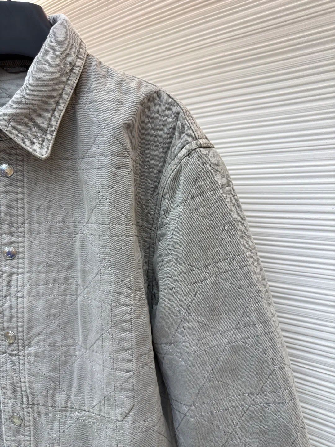 Dior cotton twill cannage pattern embroidered lapel single-breasted long-sleeved shirt ●Original version: purchased and developed by 17011 ●Item number: 1682544-C45 ●Material: cotton twill fabric ●Technology: embroidery production ●Color: gray ●Version: fitted version ●Weight: about 1045 grams ●Size: 46-48-50-52-54-56 ●Description: This quilted shirt-style jacket is made of high-weight cotton twill fabric. It has been stone-washed and enzyme-washed to give it a light gray distressed texture. The fabric is soft and skin-friendly, yet stiff and resistant to deformation and fading. The body of the garment adopts rhombus quilting technology, the stitching is even and regular, and the thin cotton filling is densely distributed, giving both warmth and breathability, and preventing cotton batting from clumping and moving around. The classic shirt lapel design is neat and elegant, the custom-made metal snaps at the placket are smooth and durable, the cuffs are adjustable sleeves, the shoulders are seamlessly spliced, and the hem is straight and fine. The overall cut is an oversized and loose silhouette, with complete customized accessories and detailed craftsmanship to show the avant-garde street style. It can be worn alone or layered, and is suitable for various wearing scenarios such as daily outings and casual commuting. The overall wiring is straight and delicate, the fabric is comfortable and soft, and the color is consistent without color difference. It can be matched with the same style to create a fashionable look and control various occasions. Customized accessories, complete with three standards, same style for men and women!