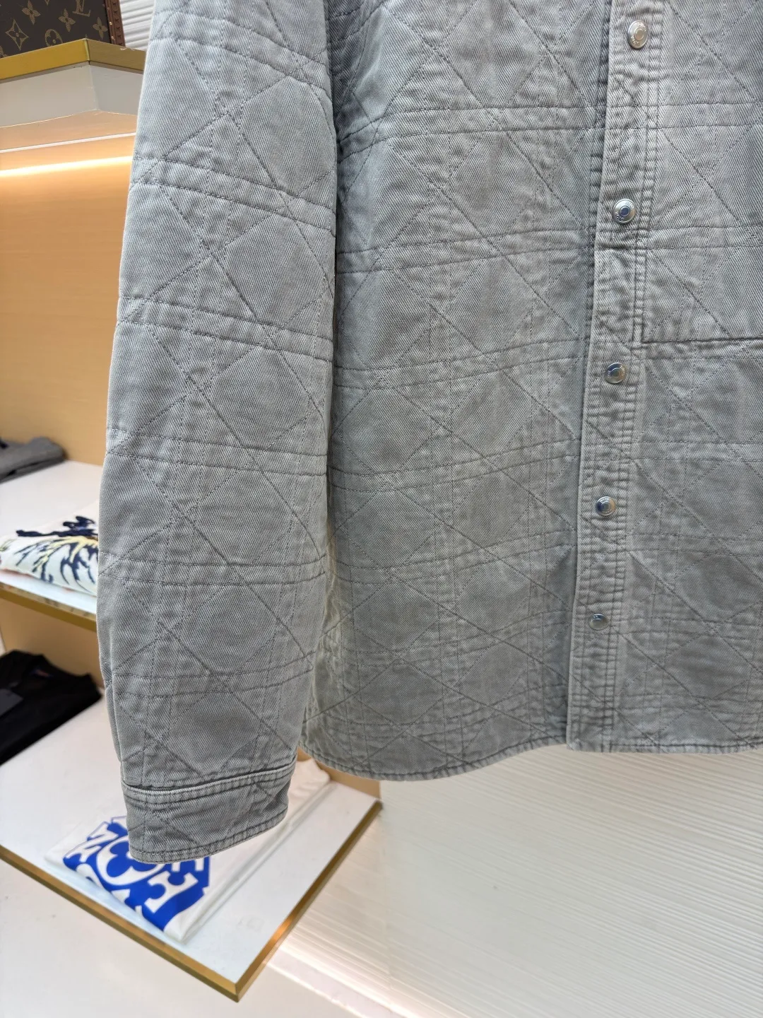 Dior cotton twill cannage pattern embroidered lapel single-breasted long-sleeved shirt ●Original version: purchased and developed by 17011 ●Item number: 1682544-C45 ●Material: cotton twill fabric ●Technology: embroidery production ●Color: gray ●Version: fitted version ●Weight: about 1045 grams ●Size: 46-48-50-52-54-56 ●Description: This quilted shirt-style jacket is made of high-weight cotton twill fabric. It has been stone-washed and enzyme-washed to give it a light gray distressed texture. The fabric is soft and skin-friendly, yet stiff and resistant to deformation and fading. The body of the garment adopts rhombus quilting technology, the stitching is even and regular, and the thin cotton filling is densely distributed, giving both warmth and breathability, and preventing cotton batting from clumping and moving around. The classic shirt lapel design is neat and elegant, the custom-made metal snaps at the placket are smooth and durable, the cuffs are adjustable sleeves, the shoulders are seamlessly spliced, and the hem is straight and fine. The overall cut is an oversized and loose silhouette, with complete customized accessories and detailed craftsmanship to show the avant-garde street style. It can be worn alone or layered, and is suitable for various wearing scenarios such as daily outings and casual commuting. The overall wiring is straight and delicate, the fabric is comfortable and soft, and the color is consistent without color difference. It can be matched with the same style to create a fashionable look and control various occasions. Customized accessories, complete with three standards, same style for men and women!