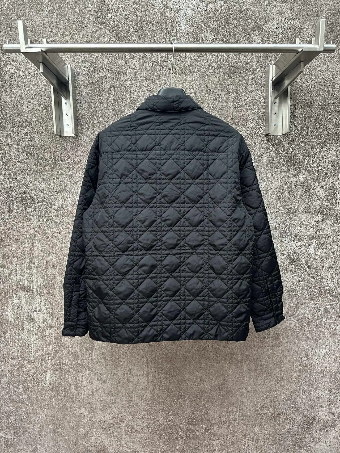 🅿️550 Dior 25ss new jacket shirt reinterprets the classic design and highlights modern style. Crafted from black technical fabric for a sleek silhouette, it's finished with a classic tonal quilted cannage pattern throughout. The chest patch pocket is decorated with +Christian+Dior+Couture+ embroidery, and the side slits are designed with snap buttons and can be worn open or buttoned. Blending traditional and modern styles, pair it with jeans or shorts for a sophisticated, stylish look.  Size: S M L XL