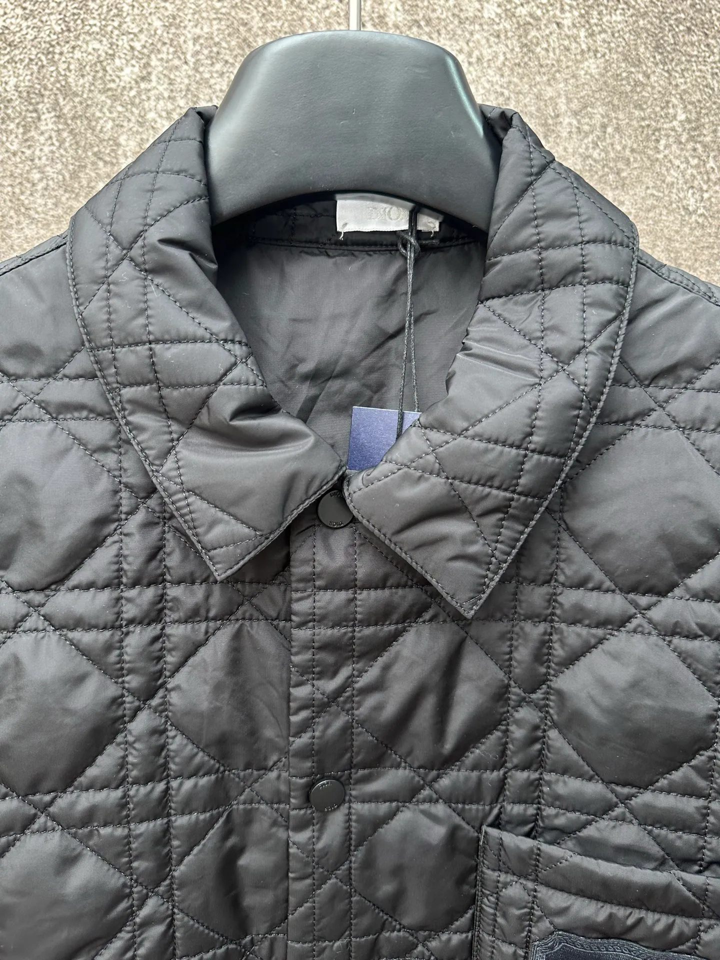 🅿️550 Dior 25ss new jacket shirt reinterprets the classic design and highlights modern style. Crafted from black technical fabric for a sleek silhouette, it's finished with a classic tonal quilted cannage pattern throughout. The chest patch pocket is decorated with +Christian+Dior+Couture+ embroidery, and the side slits are designed with snap buttons and can be worn open or buttoned. Blending traditional and modern styles, pair it with jeans or shorts for a sophisticated, stylish look.  Size: S M L XL