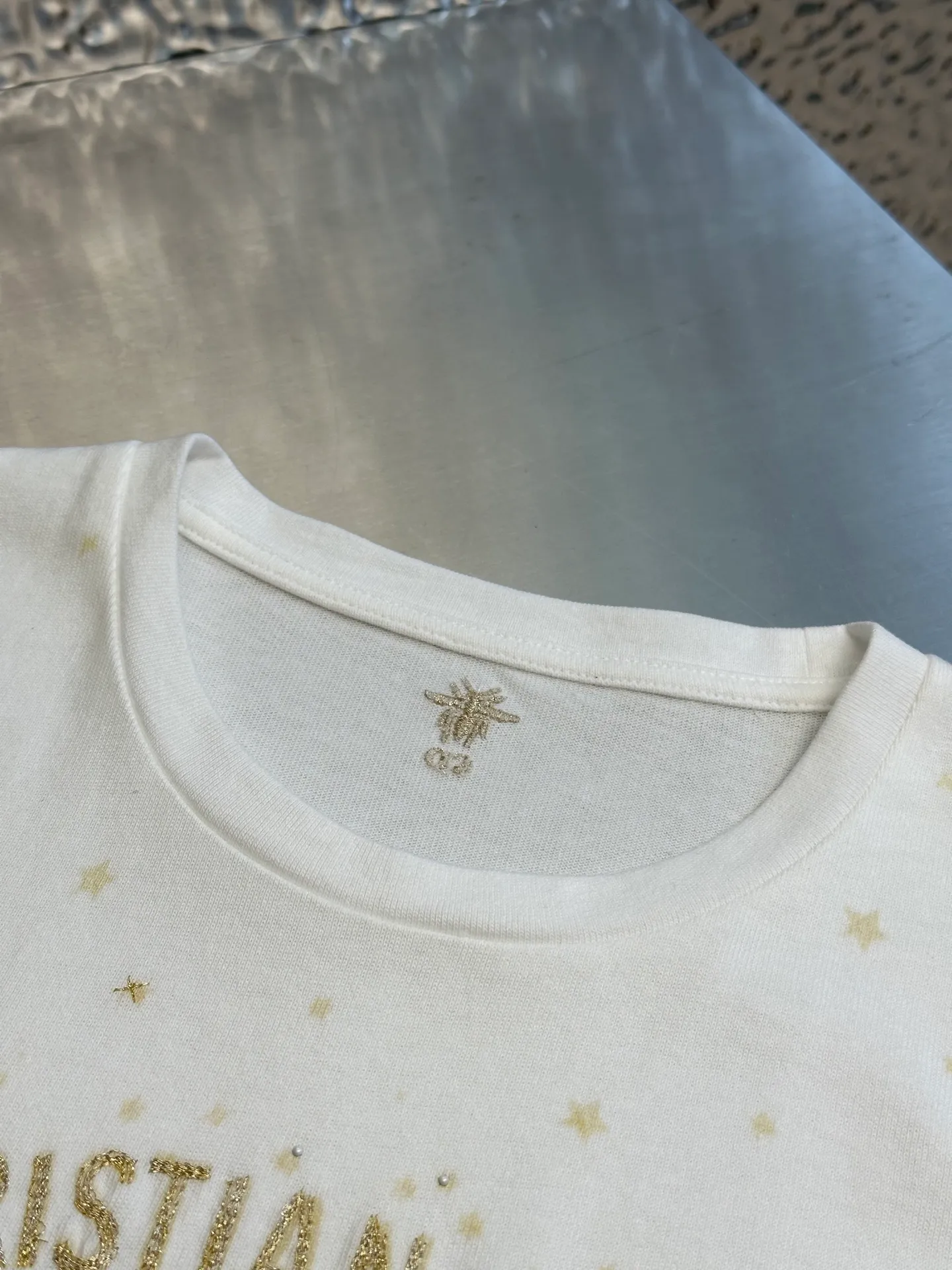 🅿️390 Women's Dior Gold Stars and Moon Heavy Embroidery Short Sleeves This T-shirt is carefully crafted from white cotton jersey fabric and decorated with gold-tone Dior Astral graphic print and embroidery, showing the Serpent and the phases of the moon, paying tribute to Mr. Dior's love for the constellations. The classic crew neck design and the Christian Dior Paris signature on the front add to the style. Pair with other Dior Astral pieces for a sophisticated and stylish look.  size：s m l