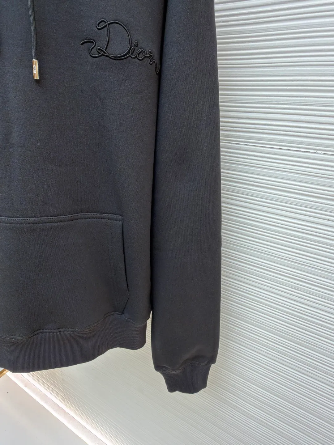 Dior woven satin badge hooded sweatshirt ●Item number: 1681708-A90 ●Material: Cotton pile terry fabric ●Technology: Ribbon letter embroidery production ●Color: gray ●Version: fitted version ●Weight: about 760 grams ●Size: XS-S-M-L ●Description: The pure cotton texture fabric is made of 26-count double yarn + 10-count bottom yarn terry fabric, with a weight of 380g/㎡; it is paired with 21-count 2x2 rib, and the composition is 95% cotton and 5% spandex. The multi-dimensional texture brought by the craftsmanship. The ribbon itself has a silky luster and smooth touch, which is in sharp and high-end contrast with the matte plush feel of the sweatshirt's suede surface. Embroidery decoration in the form of satin ribbons, which are fixed on the fabric through special processing. The texture brought by this process is usually different from the woven texture and slight luster of the main knitted fabric. It forms a delicate and accessible visual and tactile focus on the matte dark gray base, enhancing the craftsmanship, design and uniqueness of the single product. The overall wiring is straight and delicate, the fabric is comfortable and soft, and the color is consistent without color difference. It can be matched with the same style to create a fashionable look and control various occasions. Customized accessories, complete with three standards, same style for men and women!