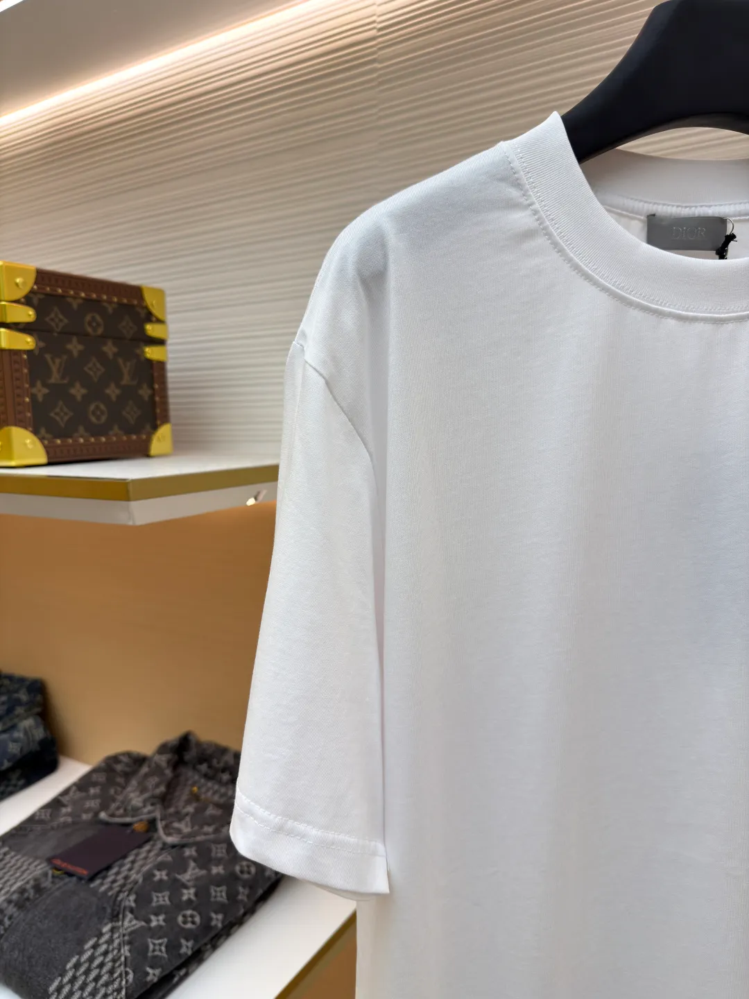 Dior Alpine Embroidery Round Neck Short Sleeve ●Original version: Purchased and developed by 7149 ●Item number: 1681102-A05 ●Fabric: plain knitted fabric ●Technology: White ink direct injection production ●Version: Fitted version ●Weight: about 200 grams ●Size: XS-S-M-L ●Description: The main body is made of 24S special woven compact cotton to make plain knitted fabric, weight 180g. High-count combed cotton yarn eliminates most of the short hairiness through compact spinning process, making the yarn smoother and stronger. The woven fabric structure is extremely dense, flat and soft, with excellent anti-pilling ability and durability, while retaining the natural advantages of pure cotton, which is breathable and skin-friendly. The neckline is made of 32S 1x1 rib with a weight of 300g. The finer yarn count creates a more delicate and tight thread, which provides better elasticity and deformation resistance than ordinary ribs, ensuring that the neckline can still remain stiff after being put on and taken off many times. The printed pattern and classic logo inspired by the mountain spirit on the chest become the visual focus through the decoration combined with multiple techniques. The printed pattern elements use digital white ink direct injection technology, which presents bright, opaque white and color patterns on dark fabrics with clear edges and a smooth touch. The classic logo is completed with fluorescent green contrasting letters in the form of patches, which are then precisely sewn onto the fabric using appliqué technology. This process restores the three-dimensionality, color saturation and detail accuracy of the pattern to the original version. With the standard round neck shape and basic color, this product has established a high degree of matching tolerance. It can be mixed and matched with daily jeans or shorts, catering to the pursuit of functionality, comfort and details. The neckline has a rounded arc, suitable for various face shapes and body shapes; the sleeves are moderate and end just above the elbow, showing a smart and neat image. The slim-fitting cut shows off the wearer's body curves without sacrificing comfort. The collar, cuffs, hem and other parts are all sewn with fine double-needle stitching. The overall wiring is straight and delicate, the fabric is comfortable and soft, and the color is consistent without color difference. It can be matched with the same style to create a fashionable look and control various occasions. Customized accessories, complete with three standards, same style for men and women!