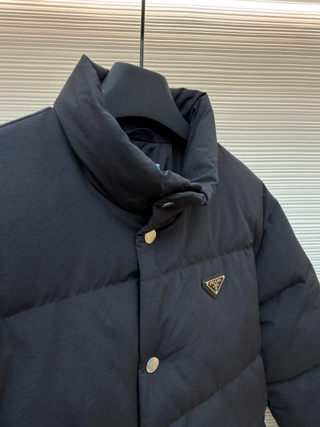 Prada triangle logo basic down jacket ●Original version: purchased and developed by 23122 ●Item number: 1681859-D15 ●Fabric: white duck down fabric ●Technology: mechanical down filling ●Color: black ●Version: fitted version ●Weight: about 1060 grams ●Size: S-M-L-XL ●Description: It is made of extremely fine nylon yarn and is woven in a high-density manner. The number of yarns per unit area is large, and the gaps between the yarns are very small, which can effectively block the penetration of cold wind. The fine weave keeps it lightweight and soft to the touch, physically restricting the lightweight down fibers from slipping through the gaps. Nylon fiber itself has good wear resistance and is not easy to snag, which significantly extends its service life and can easily cope with the needs of multiple scenarios. The lining is made of high-density weaving of 100% polyester fiber, with a thickness of 0.08mm to avoid increasing the overall weight and making it smooth to wear. The high-density weaving structure forms a wind resistance layer to protect the thermal efficiency of the thermal layer from loss. It can withstand the expansion pressure of down and prevent deformation and damage after long-term use. Each buckle is suspended independently, and in the carefully controlled current and solution, a 360-degree uniform coating without dead ends is achieved, which has stronger wear resistance and corrosion resistance. The interior is filled with 90% of the new national standard white duck down, with a filling capacity of up to 280 grams. The down is full and fluffy, and has excellent temperature locking performance. It is light and weightless, but can withstand the cold wind, making walking in winter as smooth as spring. The overall wiring is straight and delicate, the fabric is comfortable and soft, and the color is consistent without color difference. It can be matched with the same style to create a fashionable look and control various occasions. Customized accessories, complete with three standards, same style for men and women!