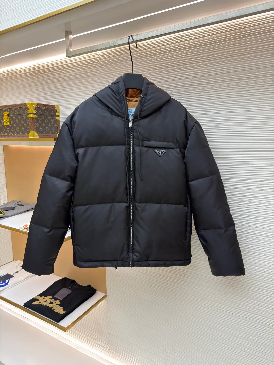 Prada Triangle Down Jacket ●Item No.: 1681316-C75 ●Fabric: White duck down fabric ●Technology: Mechanically filled with down ●Color: Black ●Version: Fitted version ●Weight: about 910 grams ●Size: S-M-L-XL ●Description: This down jacket is made of high-density water-repellent fabric, treated with a special coating, and has both windproof and anti-fouling properties. The hooded design is equipped with an adjustable drawstring, and the metal buckle at the end of the drawstring is customized by the brand, with fine texture and durability. The placket uses a two-way metal zipper with precise teeth, and the smoothness of the zipper has been tested for many rounds. The body of the garment is filled with high-quality goose down, which is evenly and plumply filled. The velvet is fixed through three-dimensional quilting technology to avoid velvet running while creating a layered silhouette. The brand triangle logo on the chest uses metal embossing + leather inlay technology, the edges are polished smooth, and the logo is three-dimensional and eye-catching. The pocket is a hidden zipper bag, and the zipper is the same color as the fabric, which is both practical and beautiful. The cuffs use micro-elastic edge processing to fit the wrist without restricting movement. The overall tailoring follows an oversize version, and seamless gluing technology is used at the splicing points to reduce thread exposure and improve wearing comfort and sophistication of garments. Every craftsmanship demonstrates Prada's strict standards for high-end clothing. The overall wiring is straight and delicate, the fabric is comfortable and soft, and the color is consistent without color difference. It can be matched with the same style to create a fashionable look and control various occasions. Customized accessories, complete with three standards, same style for men and women!