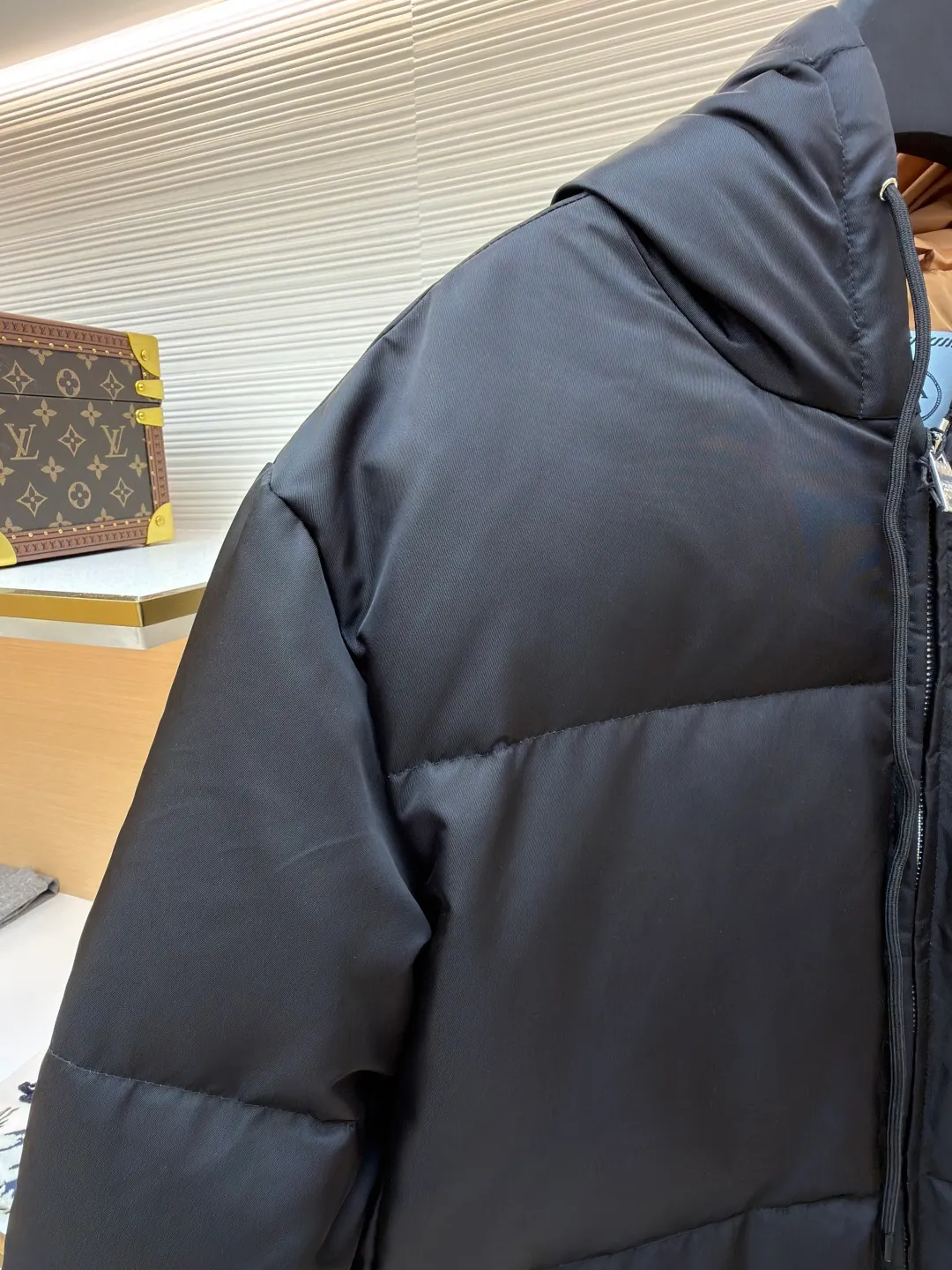 Prada Triangle Down Jacket ●Item No.: 1681316-C75 ●Fabric: White duck down fabric ●Technology: Mechanically filled with down ●Color: Black ●Version: Fitted version ●Weight: about 910 grams ●Size: S-M-L-XL ●Description: This down jacket is made of high-density water-repellent fabric, treated with a special coating, and has both windproof and anti-fouling properties. The hooded design is equipped with an adjustable drawstring, and the metal buckle at the end of the drawstring is customized by the brand, with fine texture and durability. The placket uses a two-way metal zipper with precise teeth, and the smoothness of the zipper has been tested for many rounds. The body of the garment is filled with high-quality goose down, which is evenly and plumply filled. The velvet is fixed through three-dimensional quilting technology to avoid velvet running while creating a layered silhouette. The brand triangle logo on the chest uses metal embossing + leather inlay technology, the edges are polished smooth, and the logo is three-dimensional and eye-catching. The pocket is a hidden zipper bag, and the zipper is the same color as the fabric, which is both practical and beautiful. The cuffs use micro-elastic edge processing to fit the wrist without restricting movement. The overall tailoring follows an oversize version, and seamless gluing technology is used at the splicing points to reduce thread exposure and improve wearing comfort and sophistication of garments. Every craftsmanship demonstrates Prada's strict standards for high-end clothing. The overall wiring is straight and delicate, the fabric is comfortable and soft, and the color is consistent without color difference. It can be matched with the same style to create a fashionable look and control various occasions. Customized accessories, complete with three standards, same style for men and women!