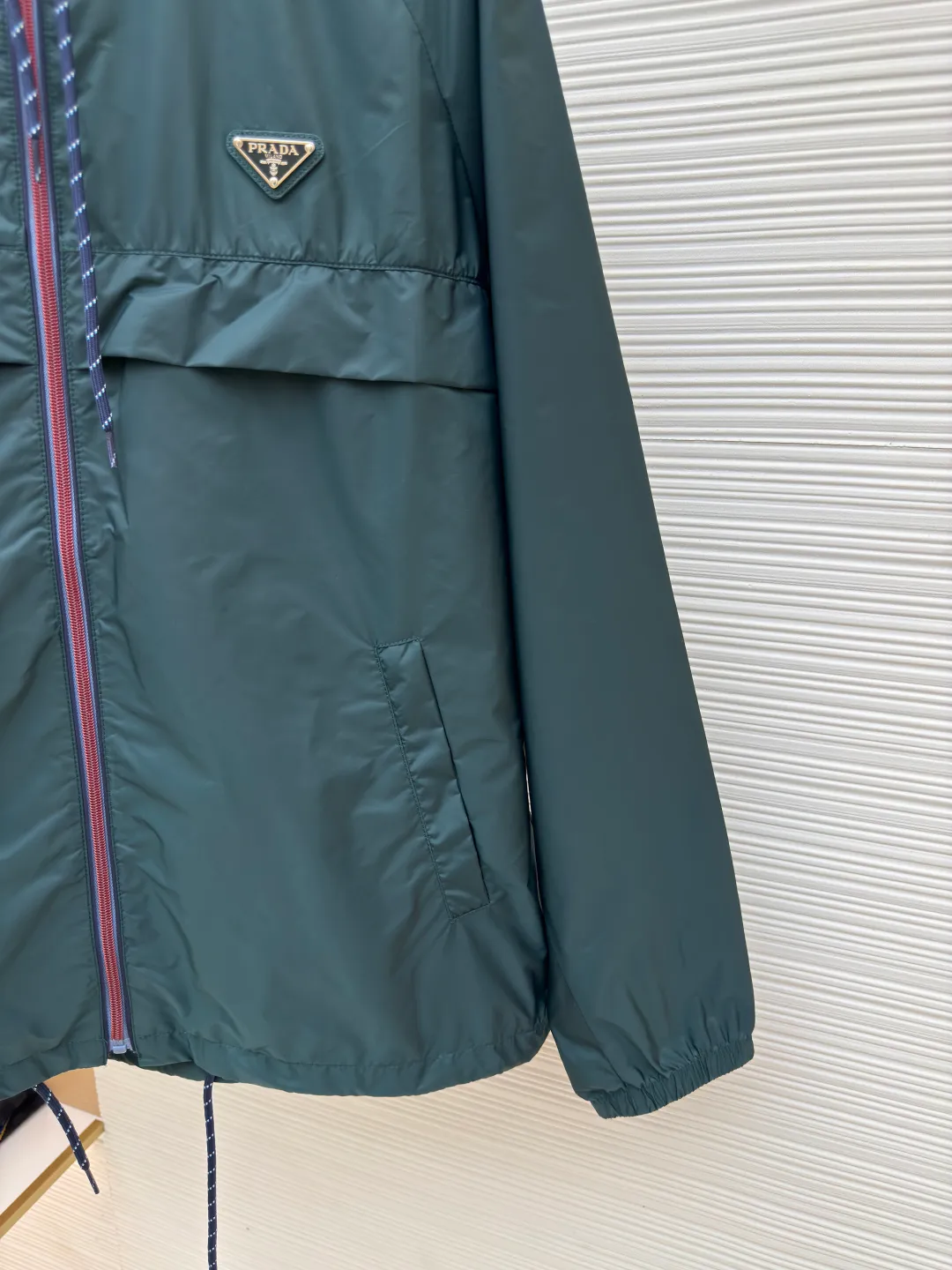 PRADA regenerated nylon jacket ●Authentic product: Purchased and developed by 16925 ●Item number: 1680069-B50 ●Fabric: nylon fabric ●Technology: Positioning cutting machine ●Version: Fitted version ●Weight: about 265 grams ●Size: 46-48-50-52 ●Description: The brand's iconic regenerated nylon fabric is selected, which has the same performance as traditional nylon, with high strength, tear resistance, wear resistance and other characteristics. It is lightweight and waterproof, suitable for various scenarios. Anti-wrinkle, quick-drying and easy to maintain on a daily basis. Using high-strength professional sewing thread, the stitch spacing is uniform and the standard setting is about 11 stitches every three centimeters. Each stitch is straight and smooth, with no skipped stitches or floating threads. The built-in stitching process ensures that the edges of the rotator cuff link are sharp, flat, and never everted. Patch pocket edges. The inner folding and wrapping process eliminates rough edges and enhances the appearance and firmness. The overall wiring is straight and delicate, the fabric is comfortable and soft, and the color is consistent without color difference. It can be matched with the same style to create a fashionable look and control various occasions. Customized accessories, complete with three standards, same style for men and women!